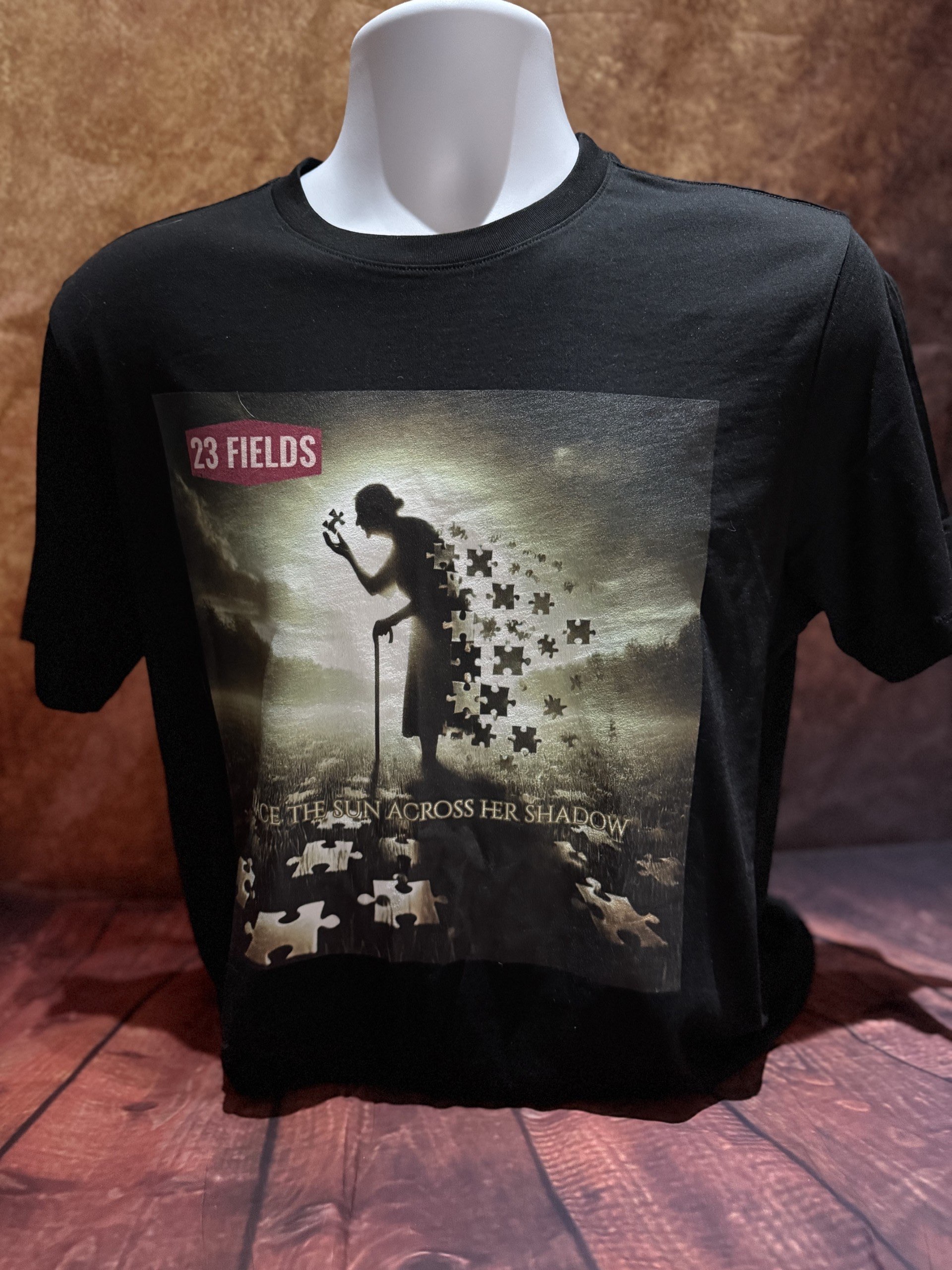 a black t - shirt with a picture of a man holding a jigsaw puzzle