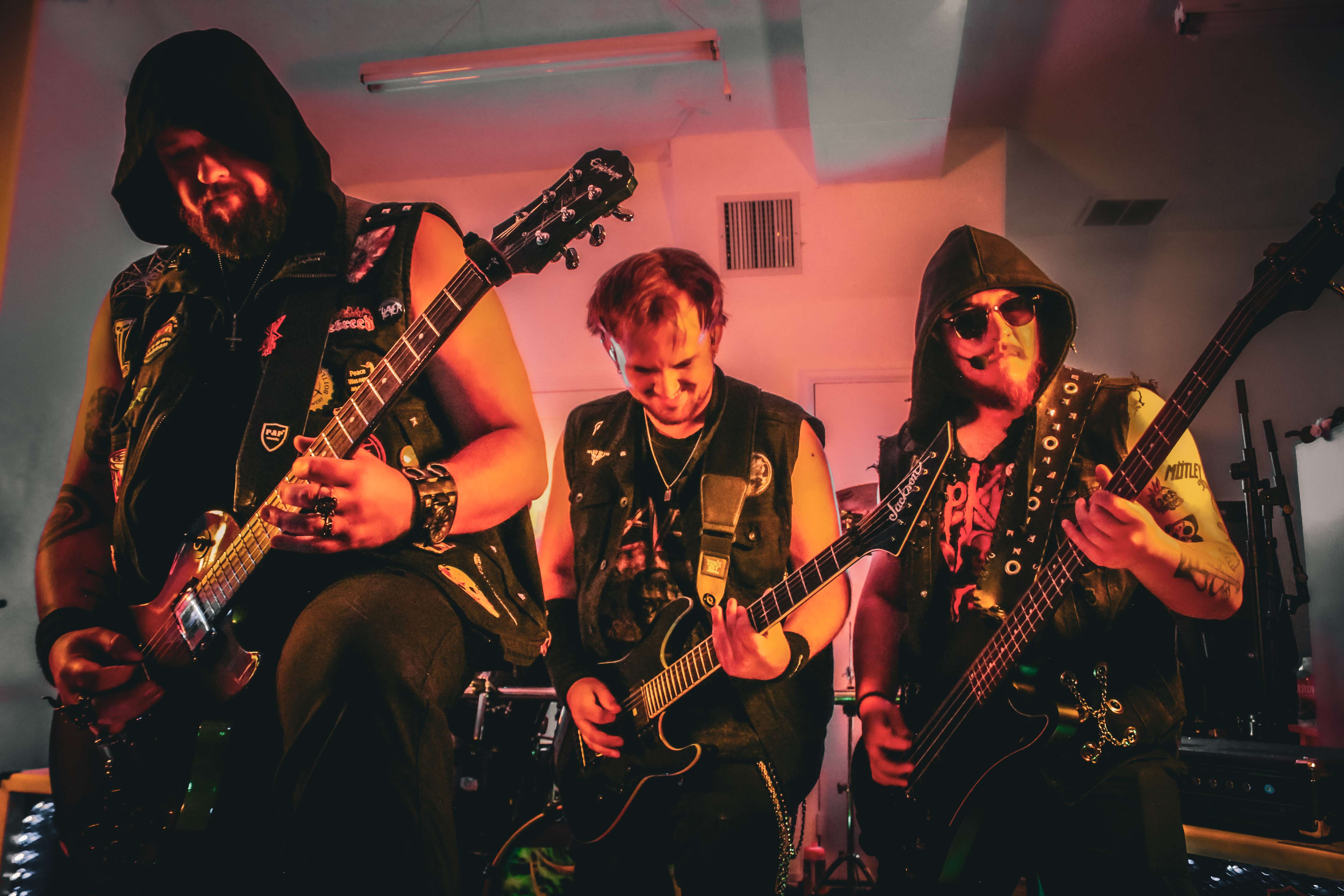 a group of men playing guitars in a dark room