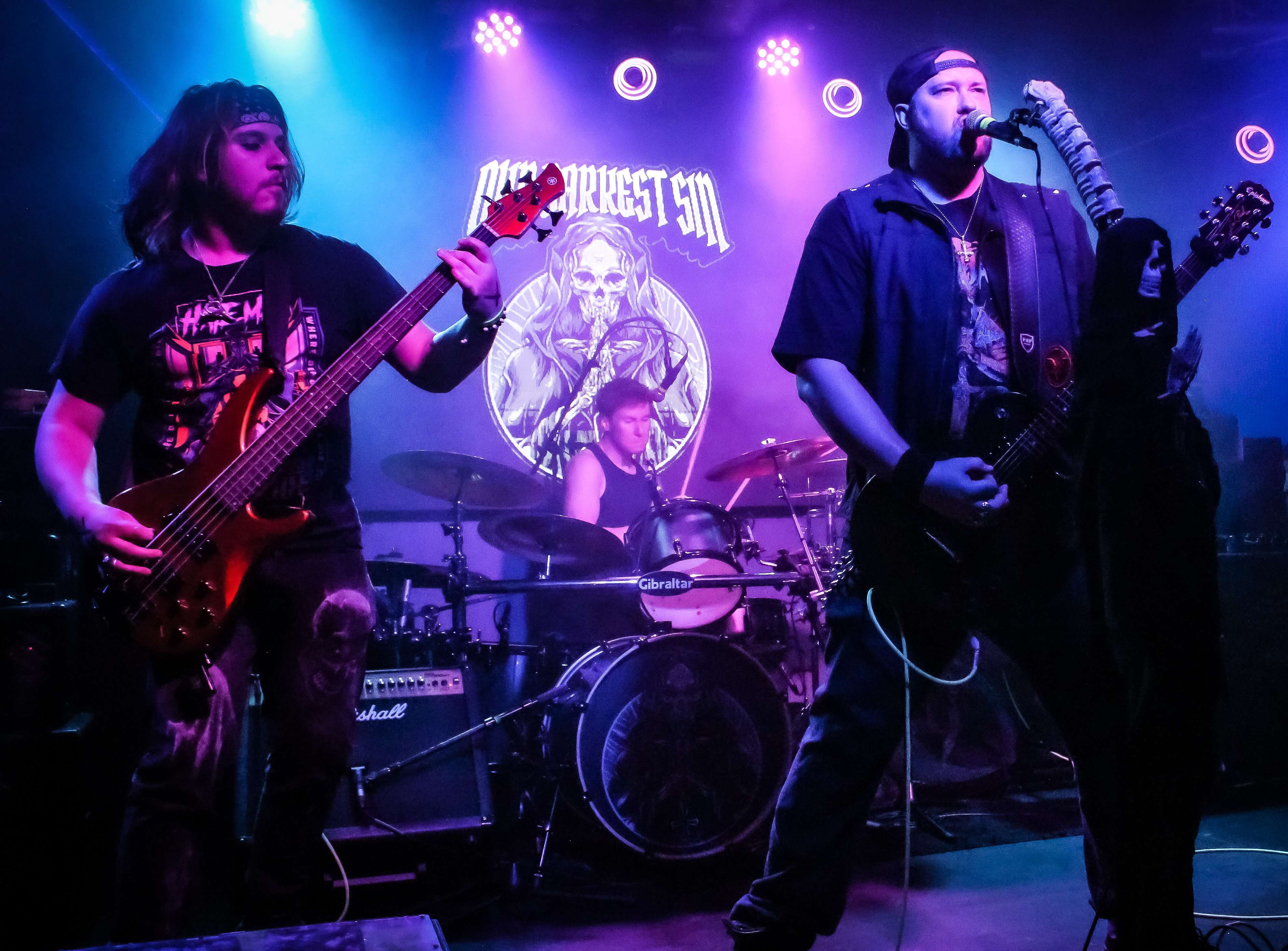 a group of men playing guitar on stage at a concert
