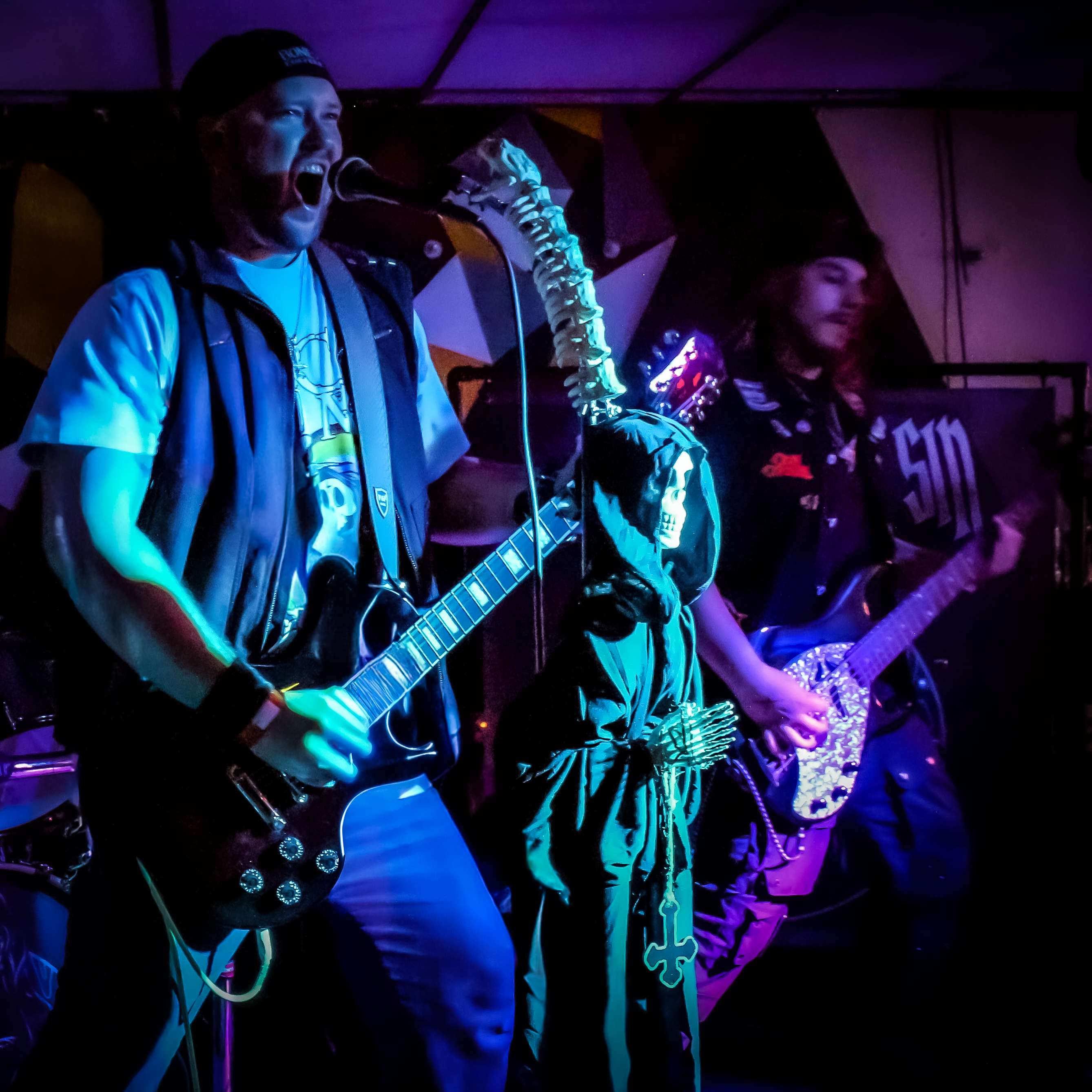 a group of men playing guitars in a dark room