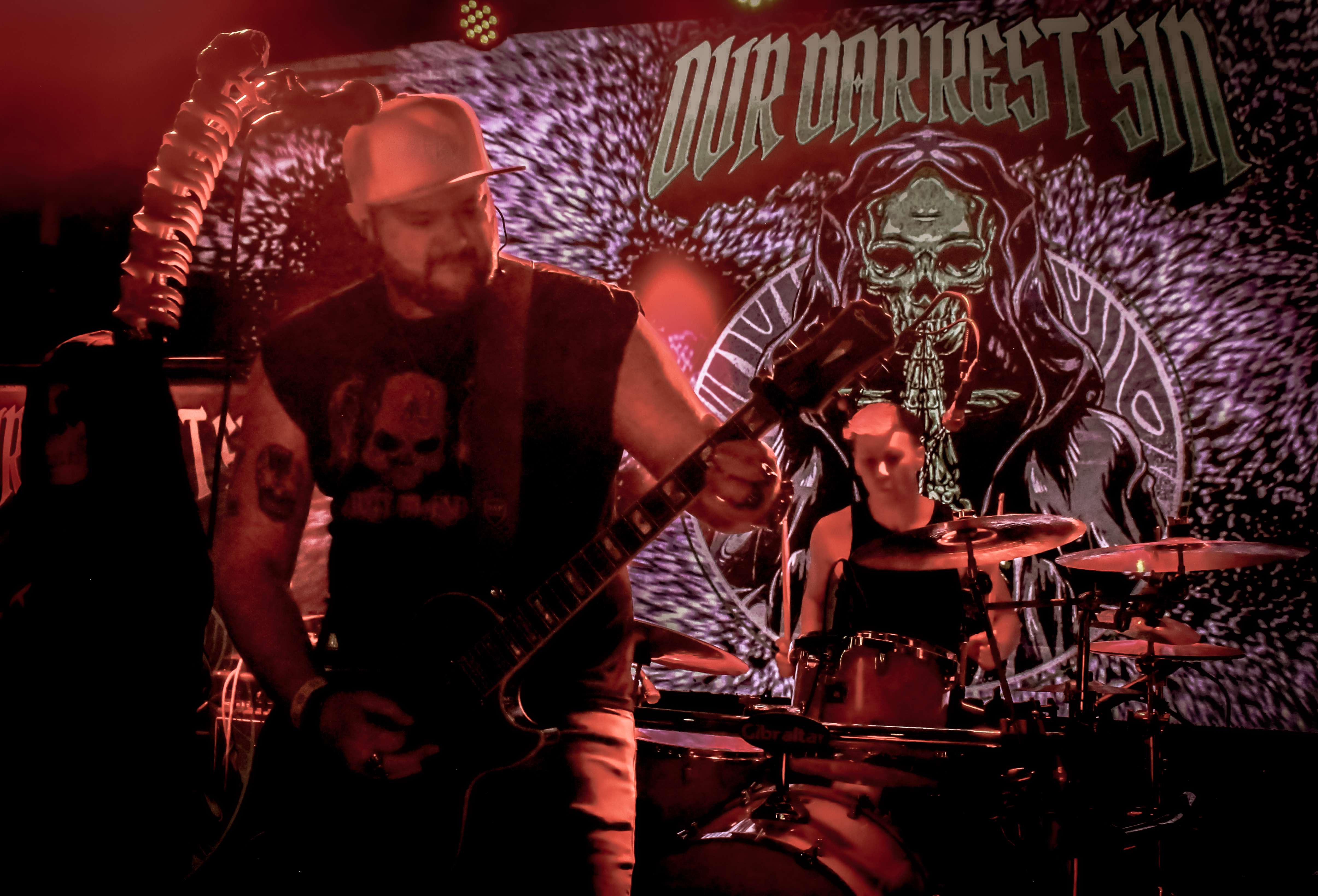 a band is playing on stage in front of a poster