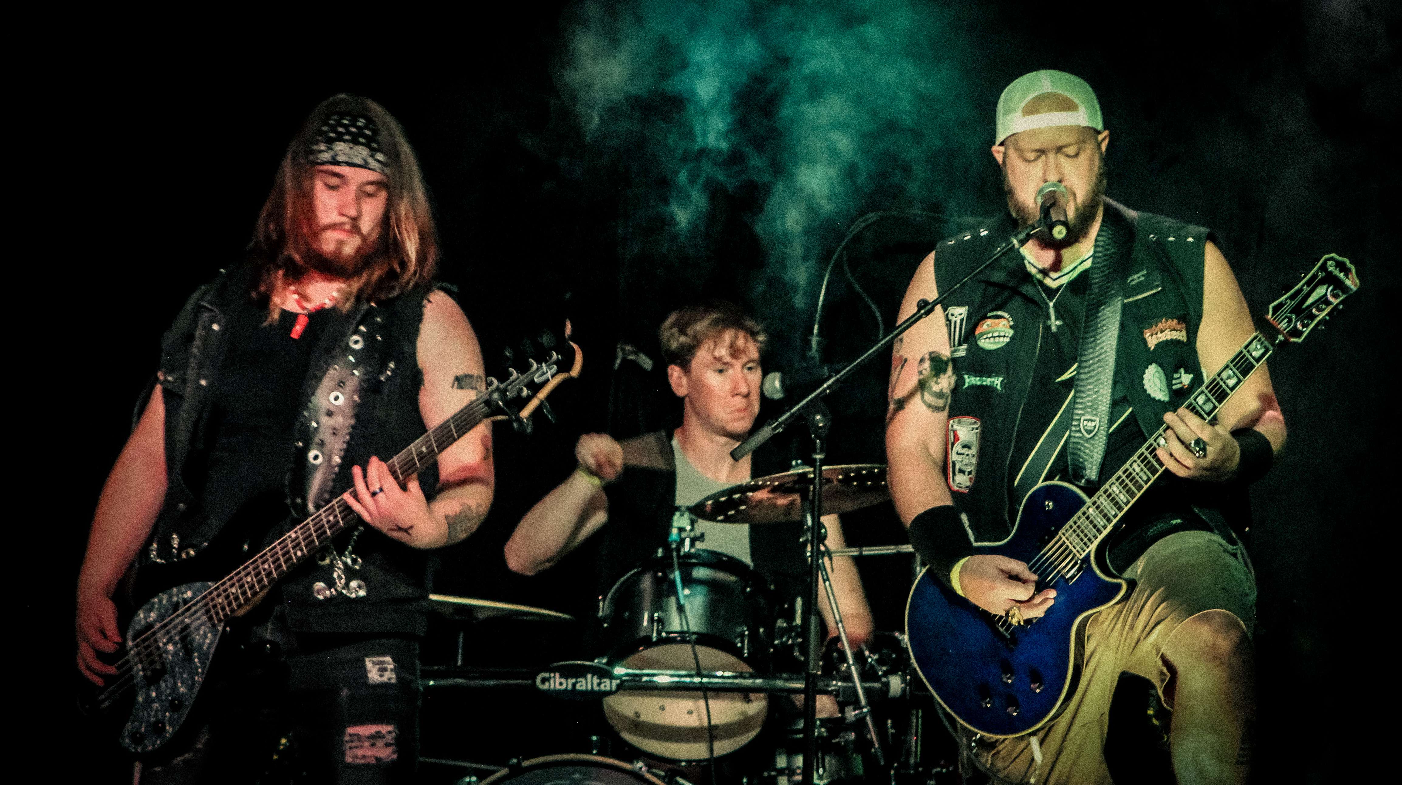 a group of men playing guitars in a dark room