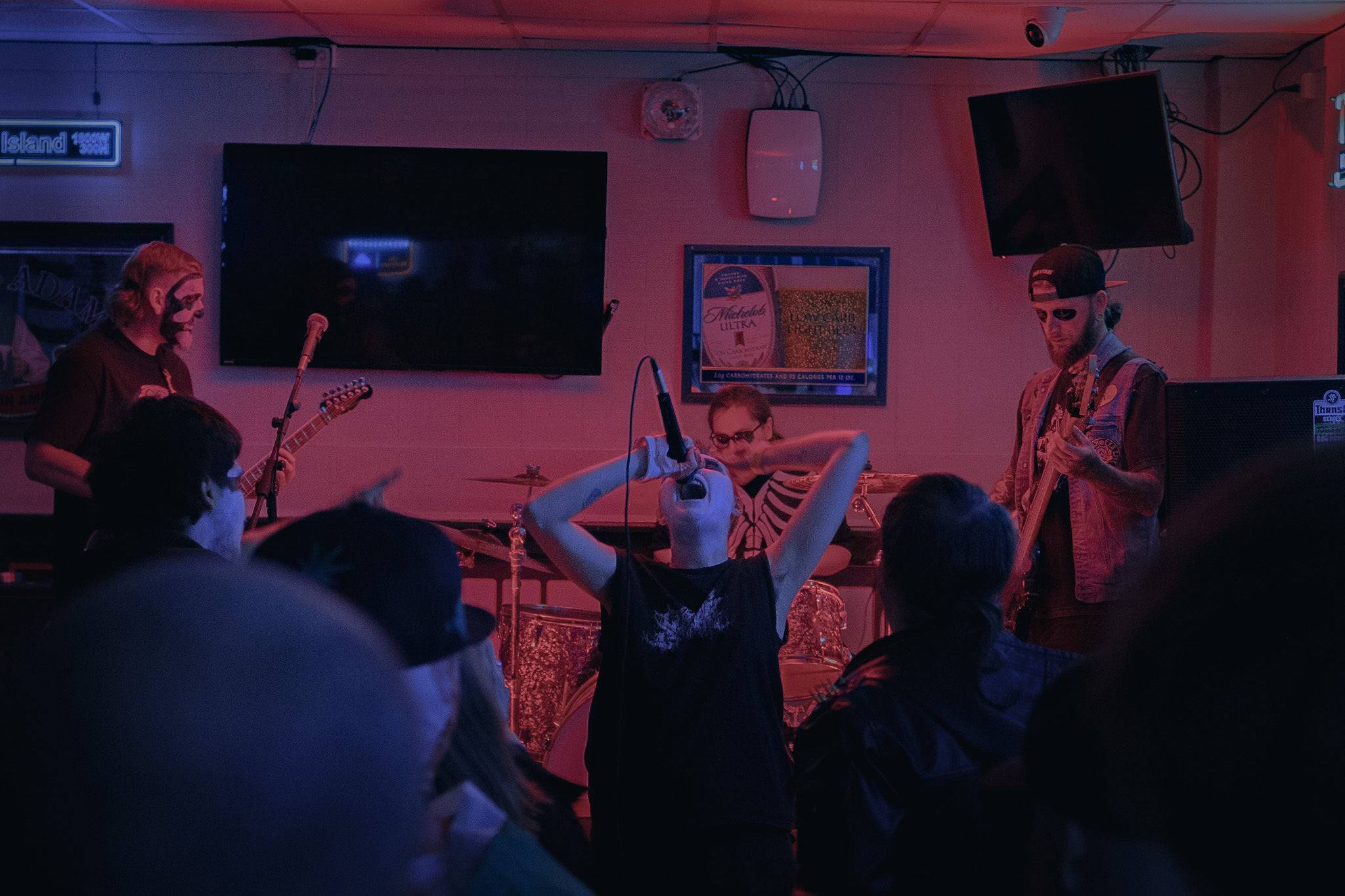 a group of people in a bar watching a band