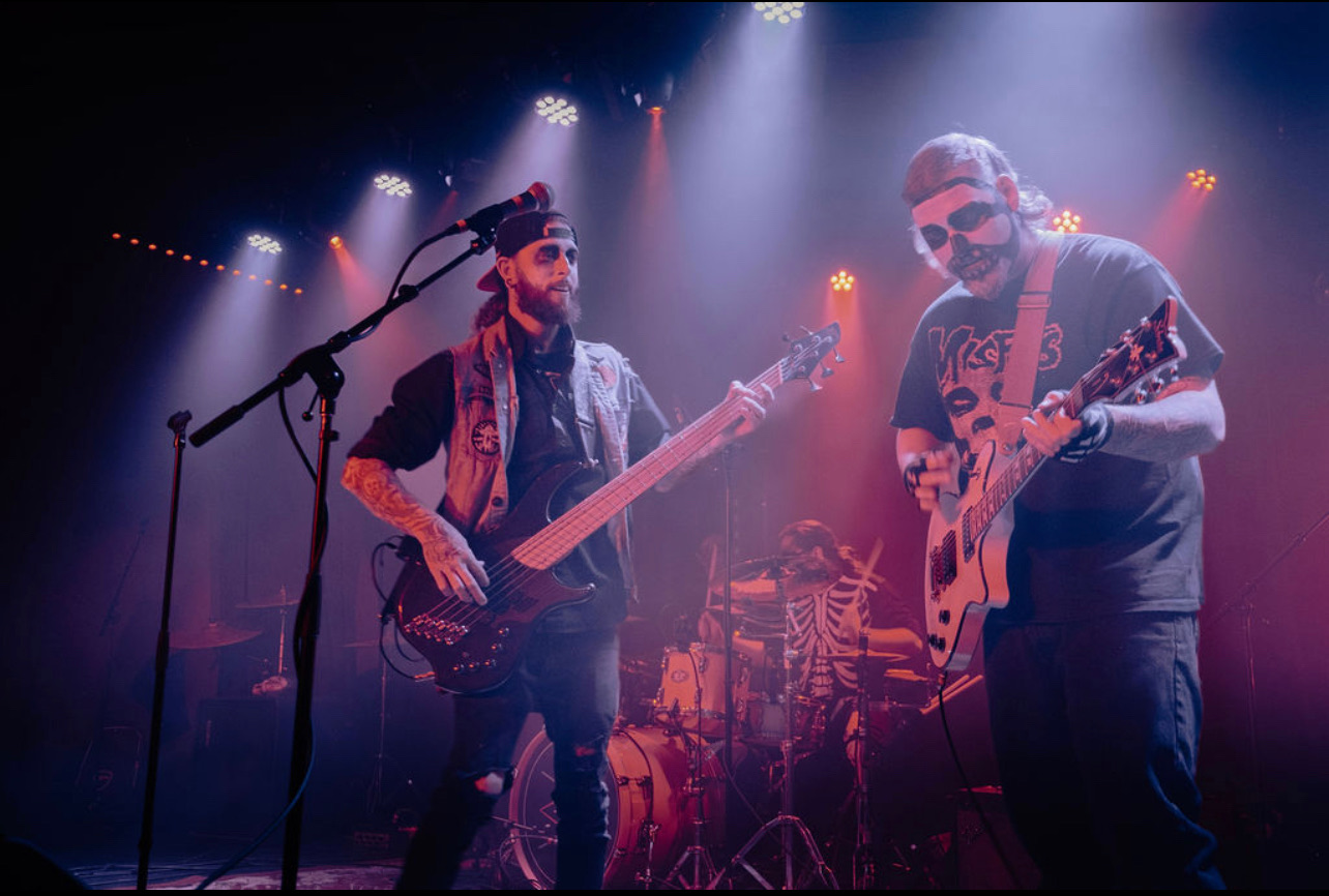 two men playing a musical instrument on stage