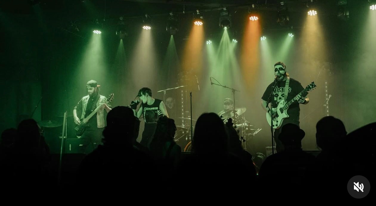 a band performs on stage in front of green lights