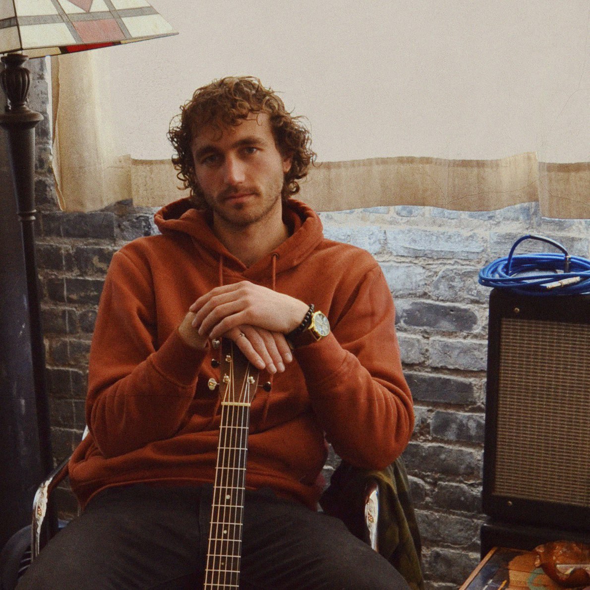 a man sitting on a chair with an acoustic guitar