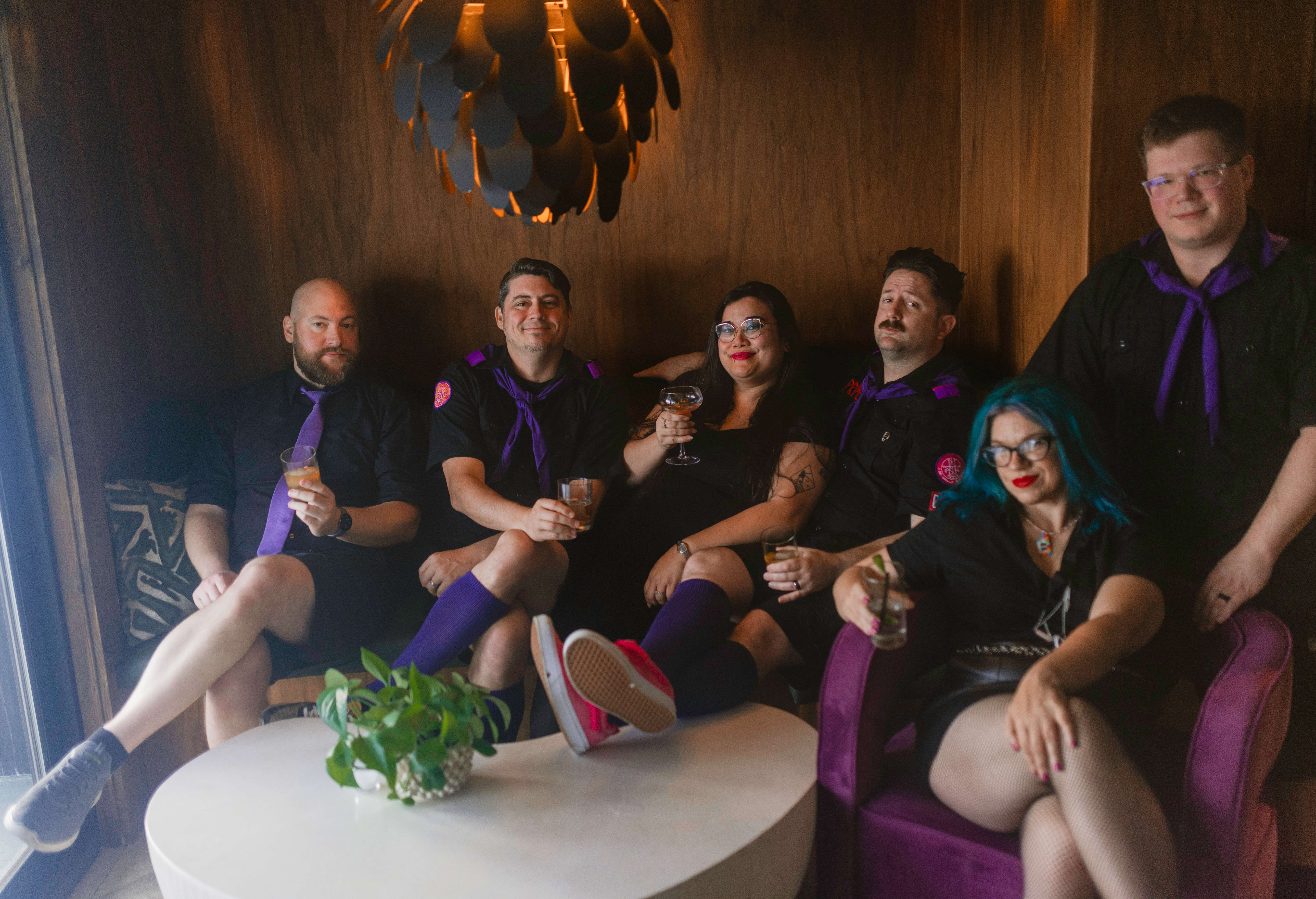 a group of people posing for a picture in a purple room