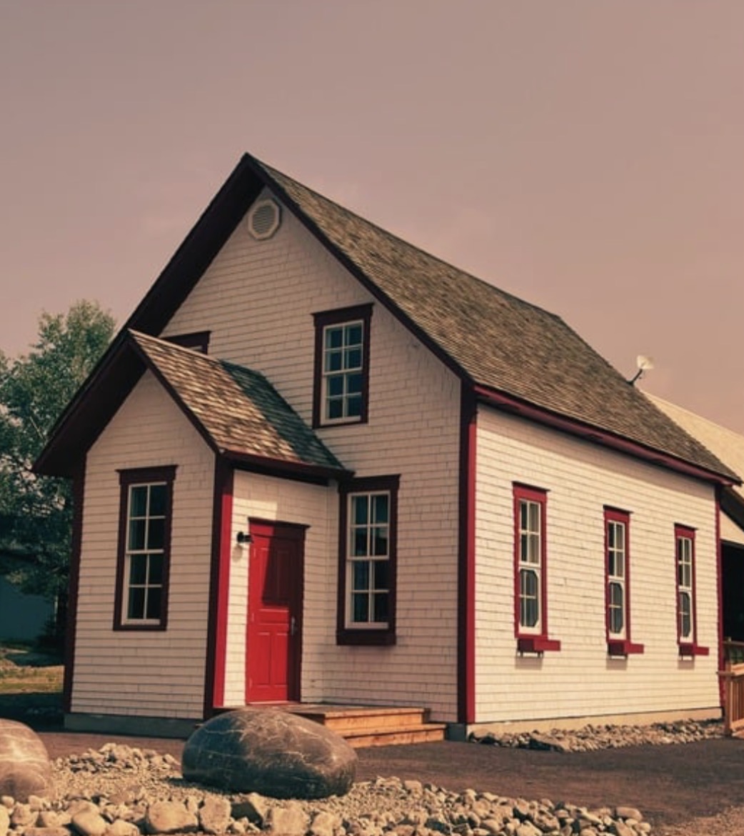 a small white house with a red door