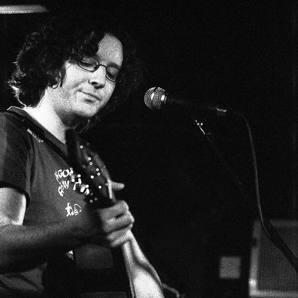 a man playing an acoustic guitar in front of a microphone