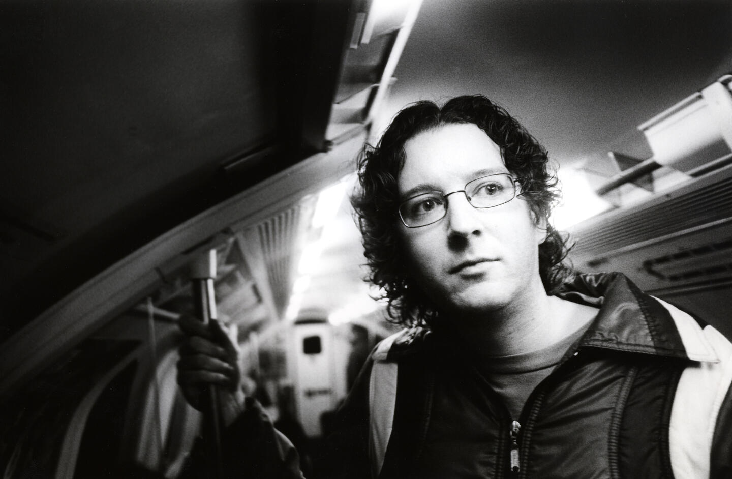 a black and white photo of a man on a train
