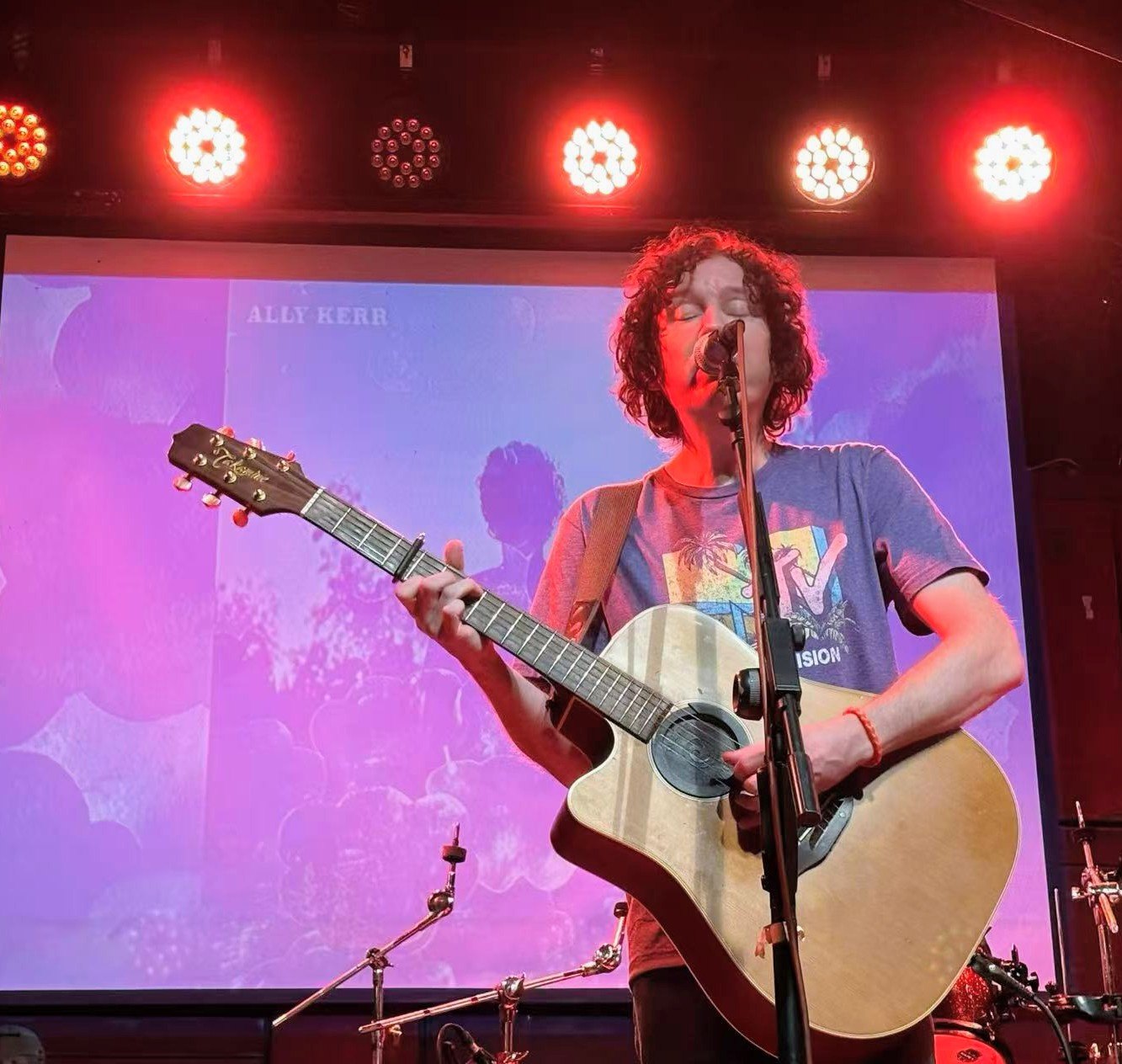 a man playing an acoustic guitar on stage
