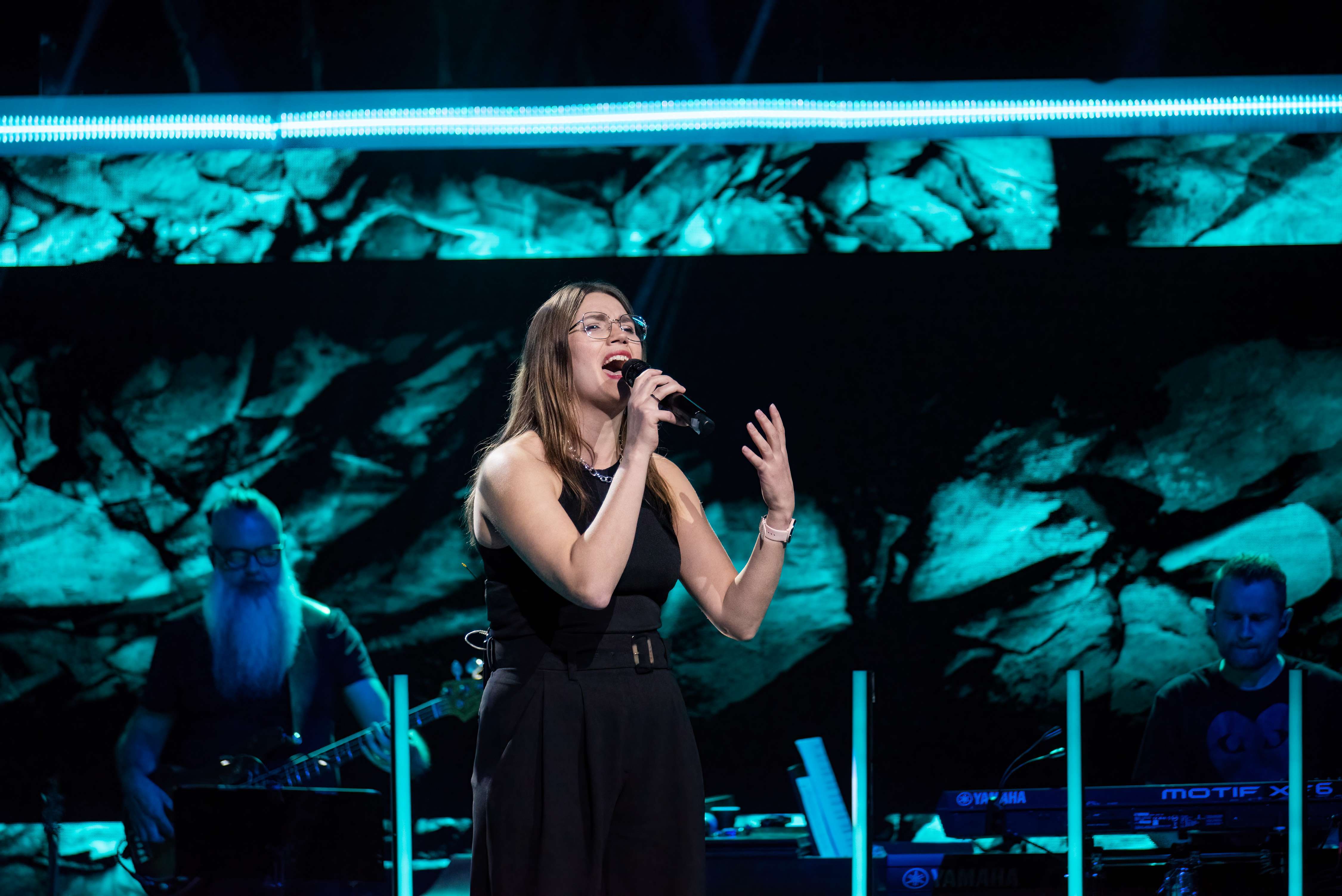 a woman singing into a microphone on stage