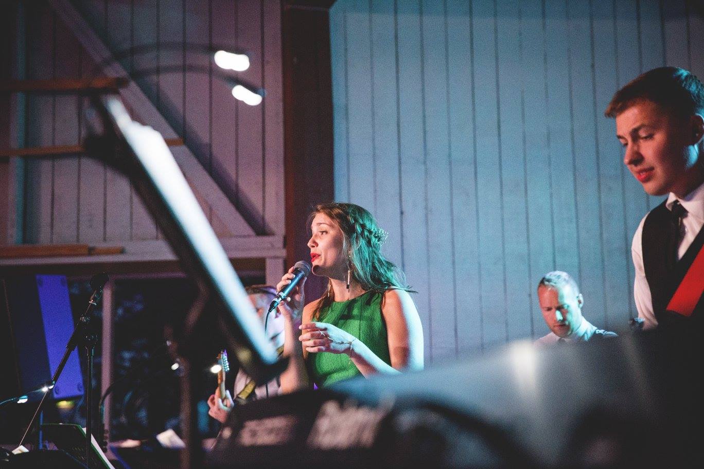 a group of people singing and playing music at a wedding