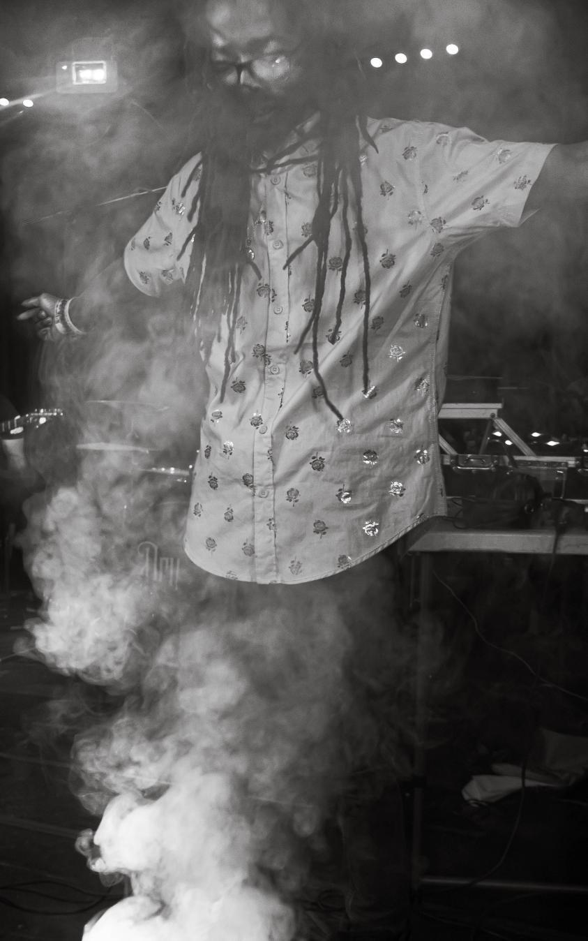 a man with dreadlocks standing in front of smoke