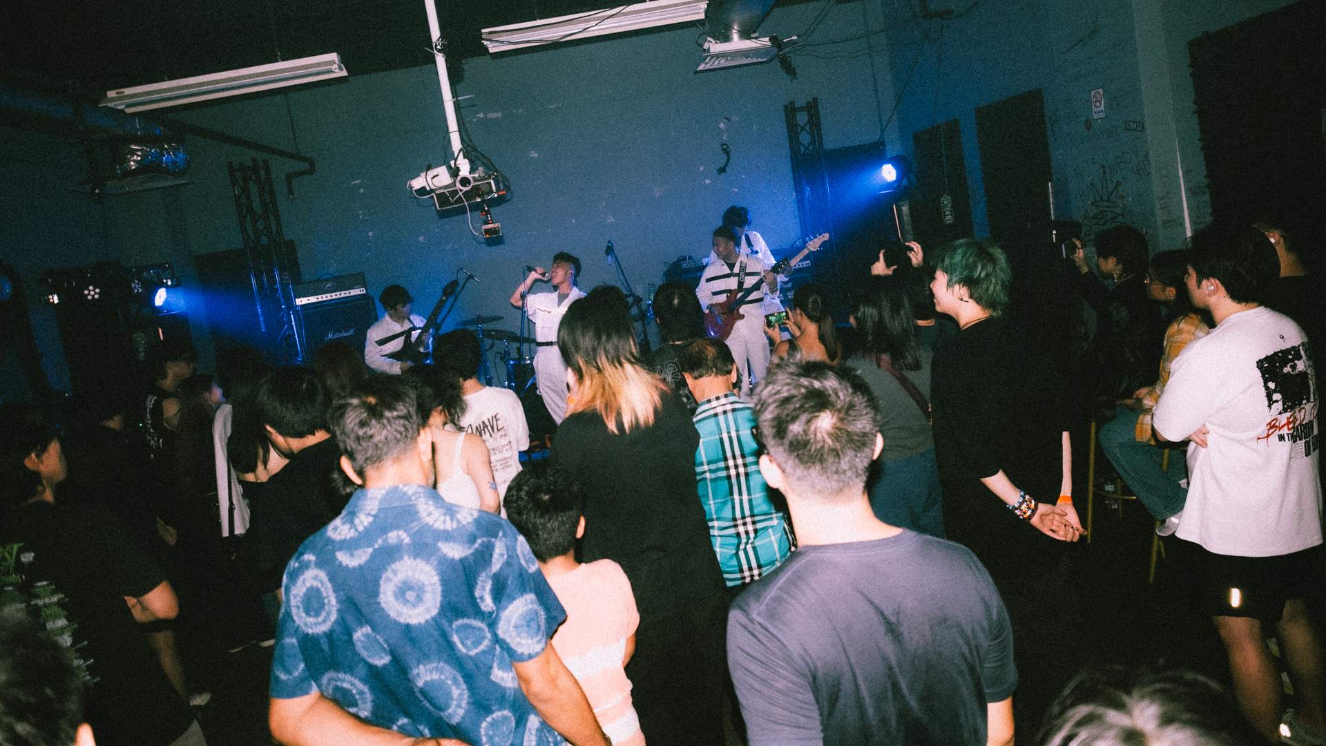 a crowd of people standing in a dark room