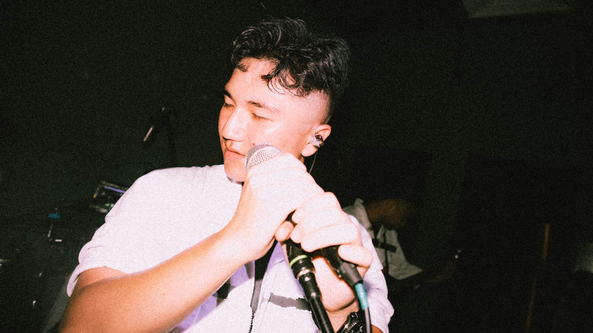 a man is holding a microphone and singing into it
