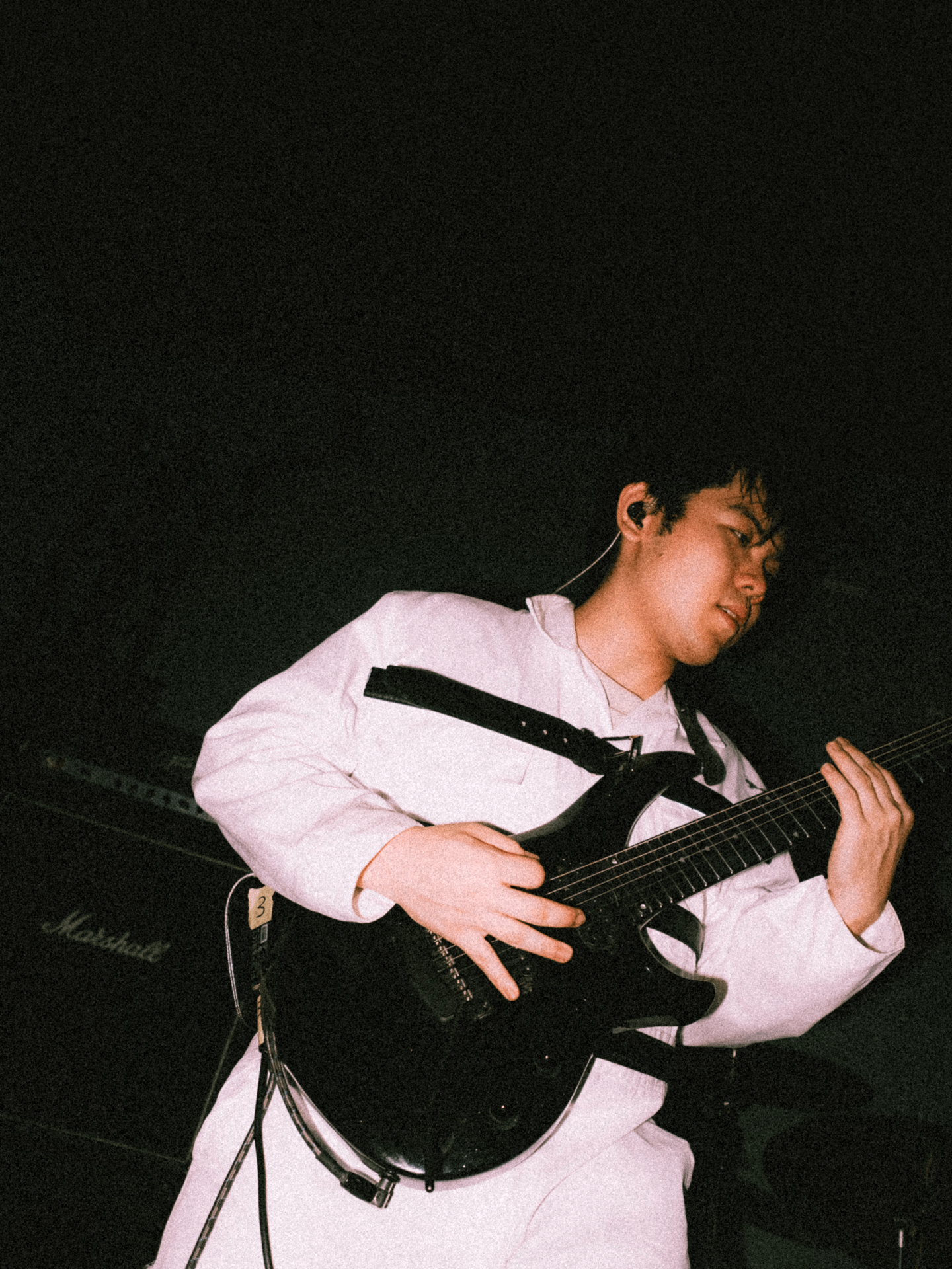 a man playing a guitar in a dark room