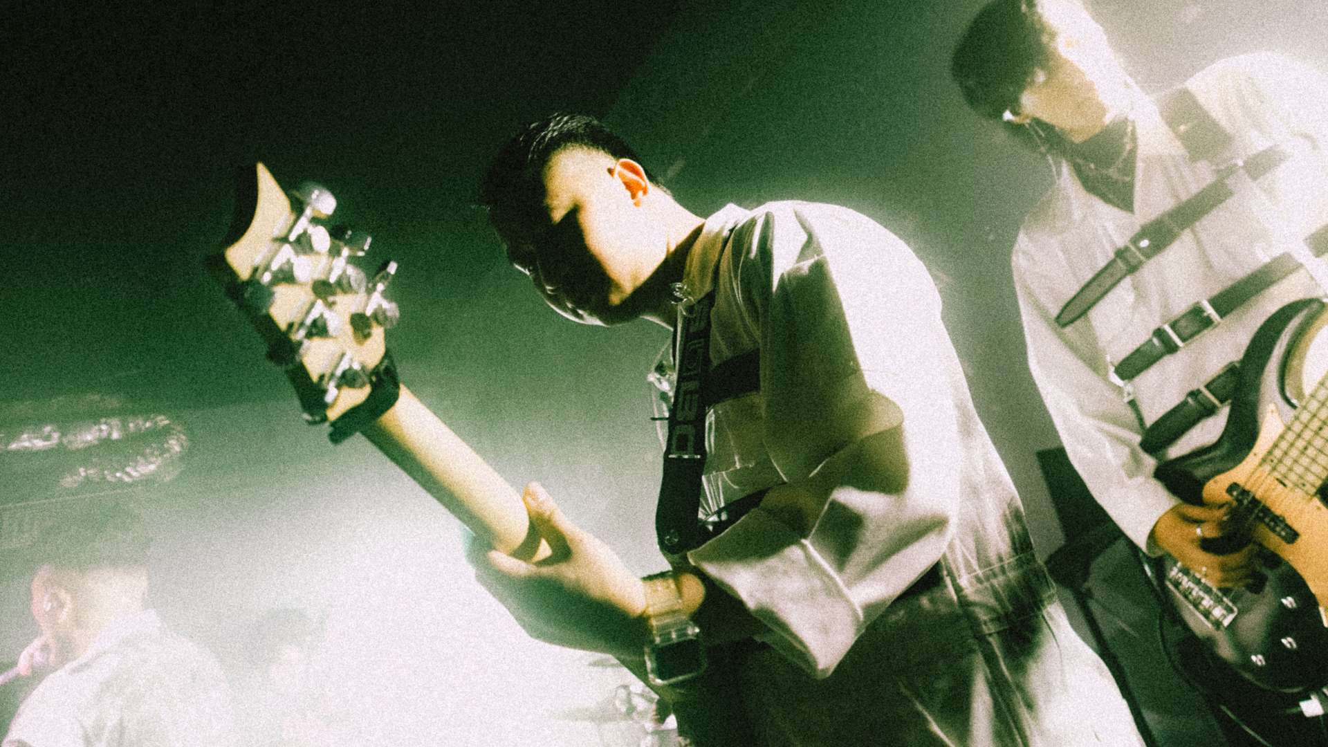 a group of people playing guitars in a dark room