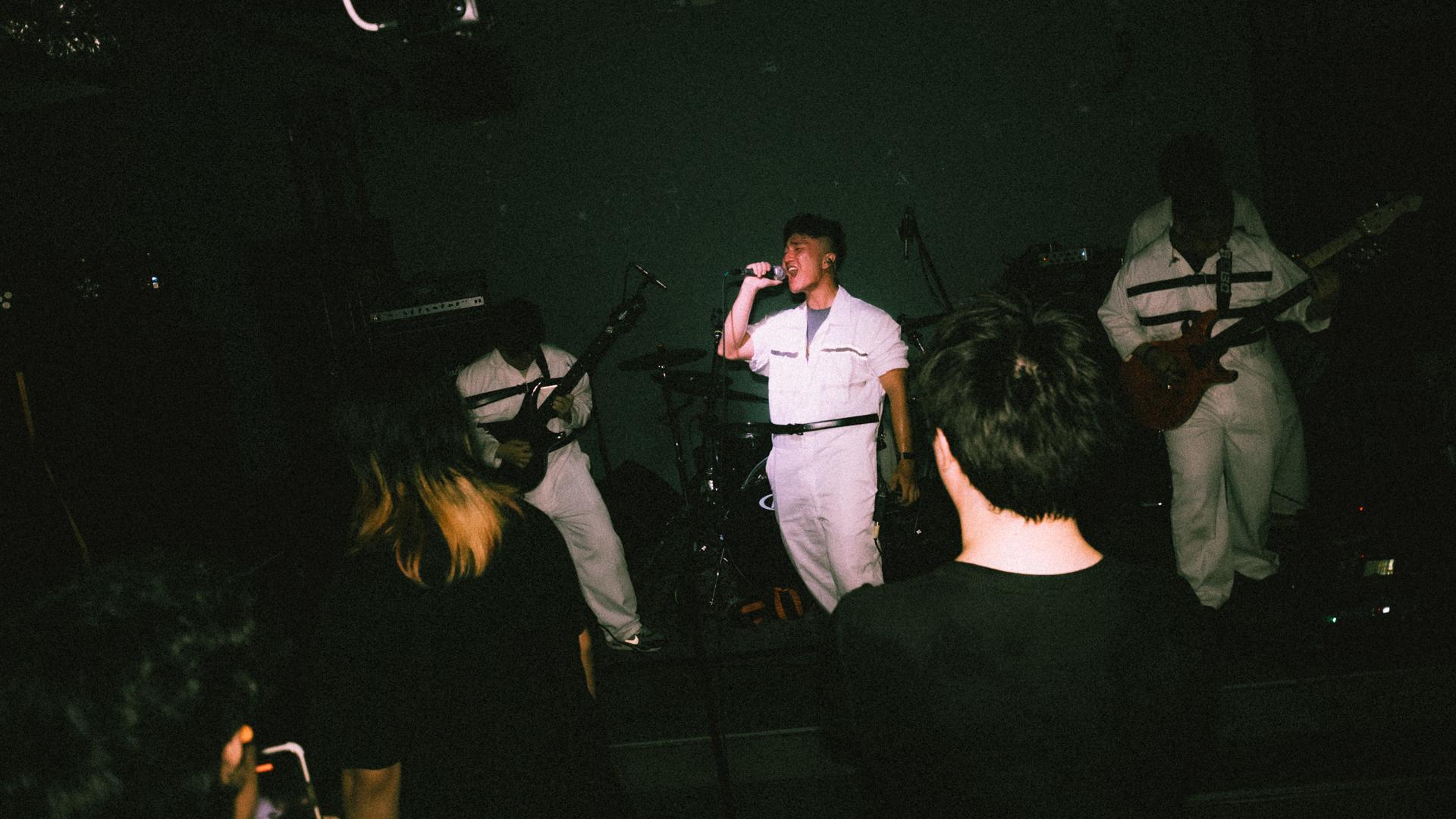 a group of people in white uniforms standing in front of a stage