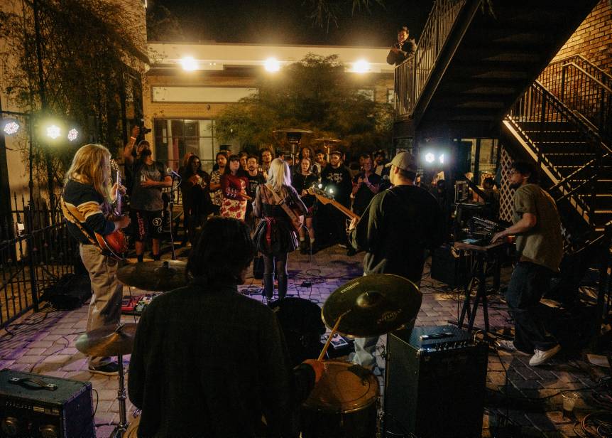 a group of people playing music in a courtyard at night