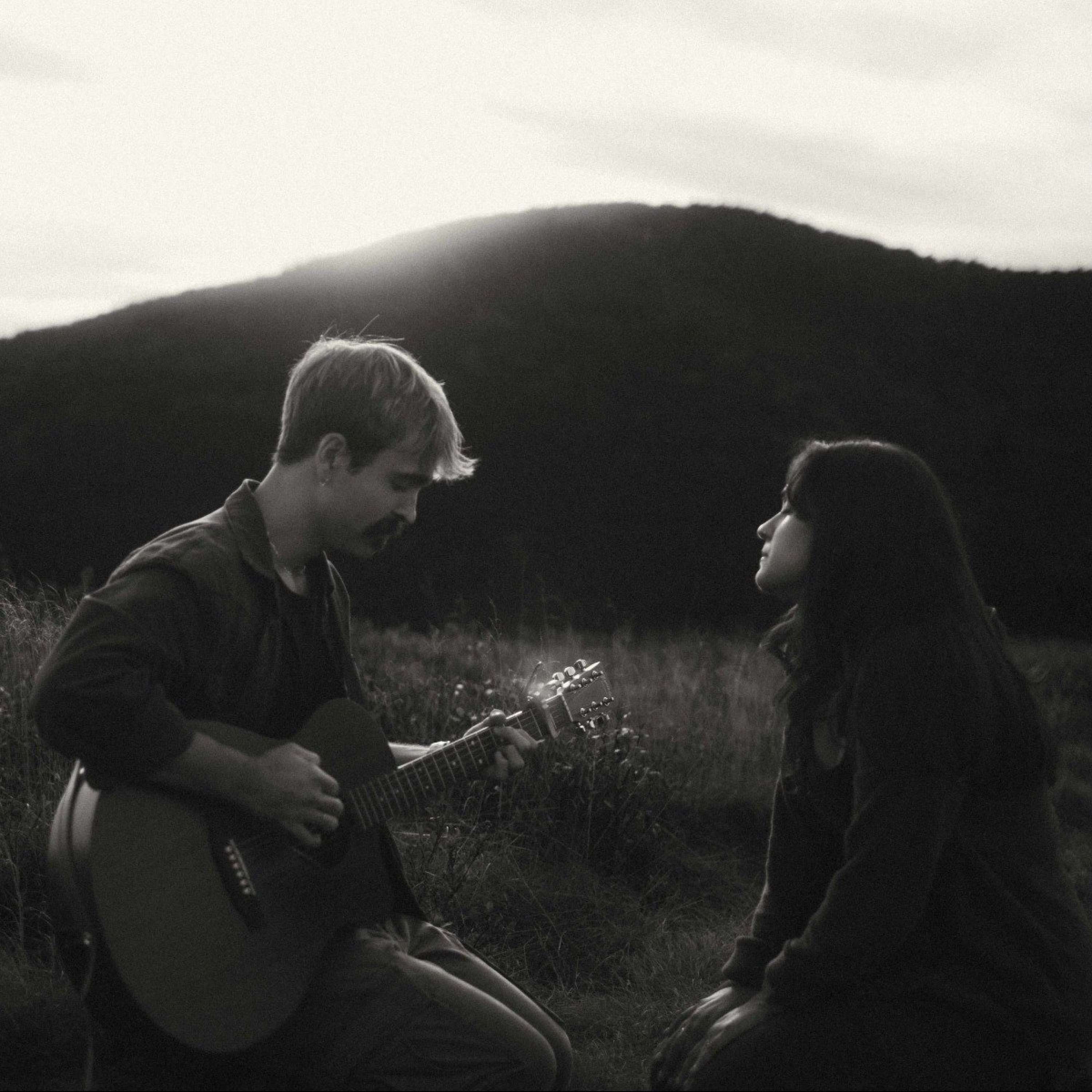 The Two Fools - Demo Derby: a man and a woman playing guitar in a field