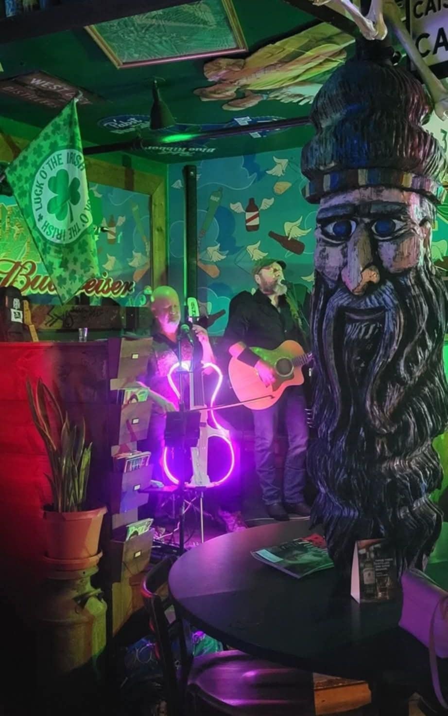 a man with a beard is playing a guitar in a bar