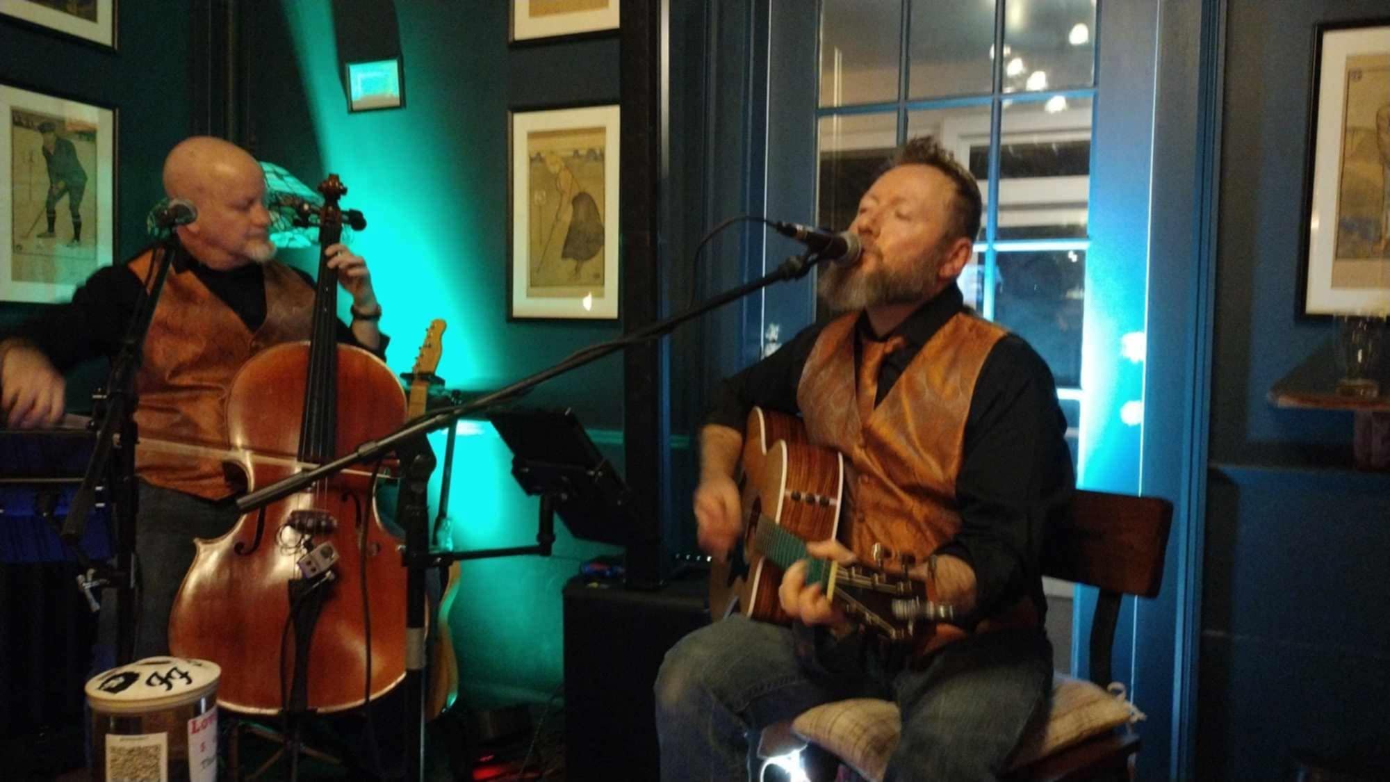 two men playing music in front of a microphone