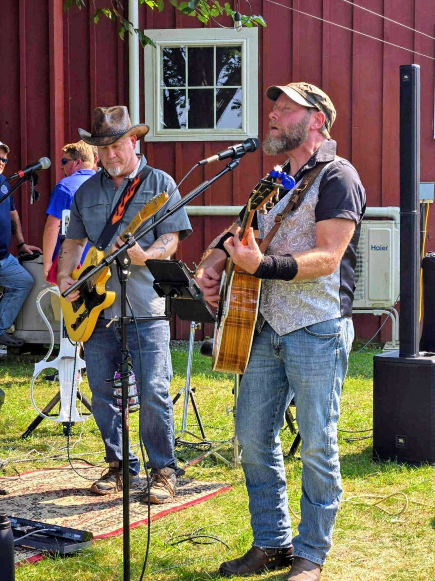 a man in a cowboy hat is singing and playing a guitar