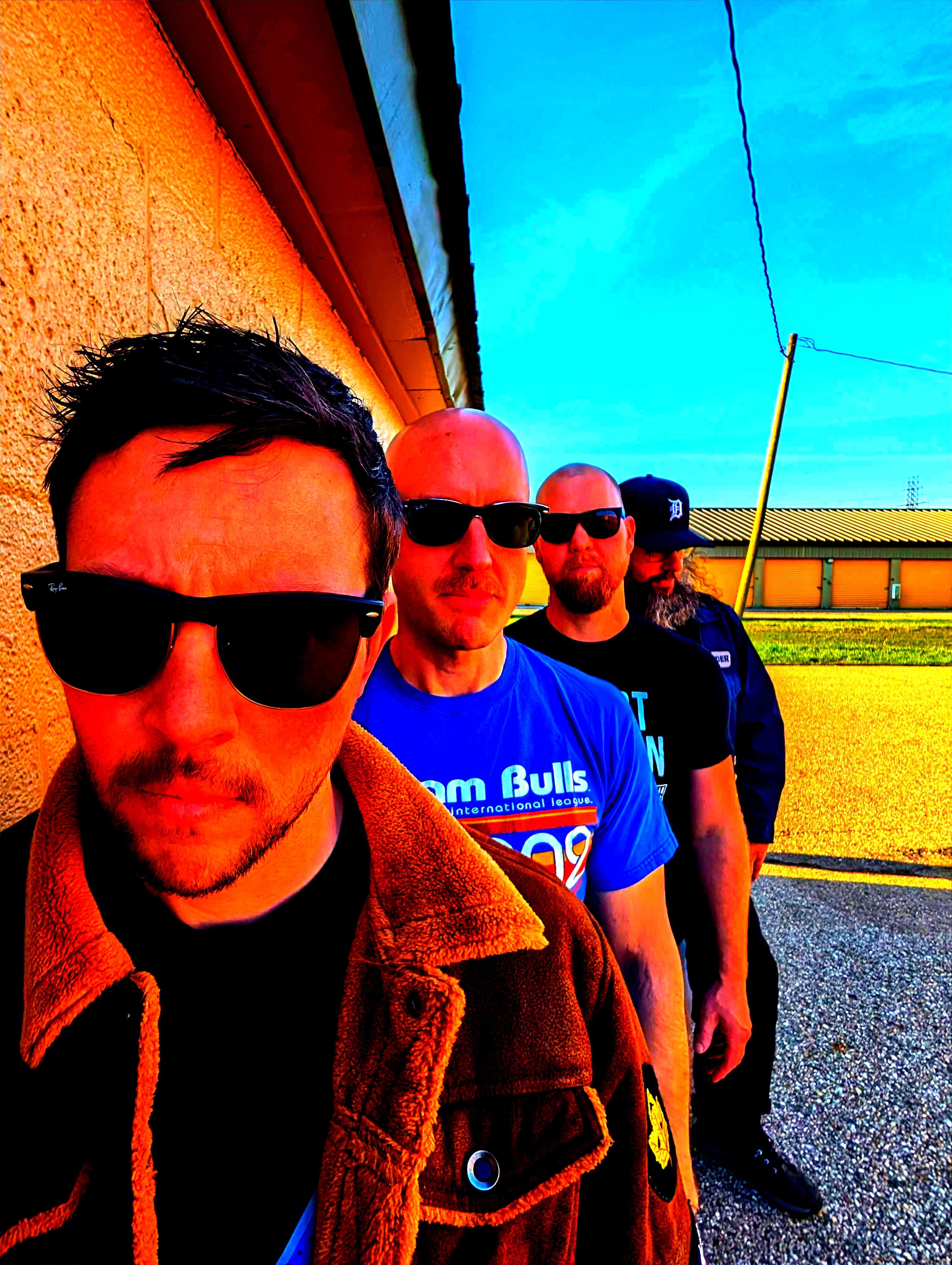 a group of men in sunglasses standing next to a wall