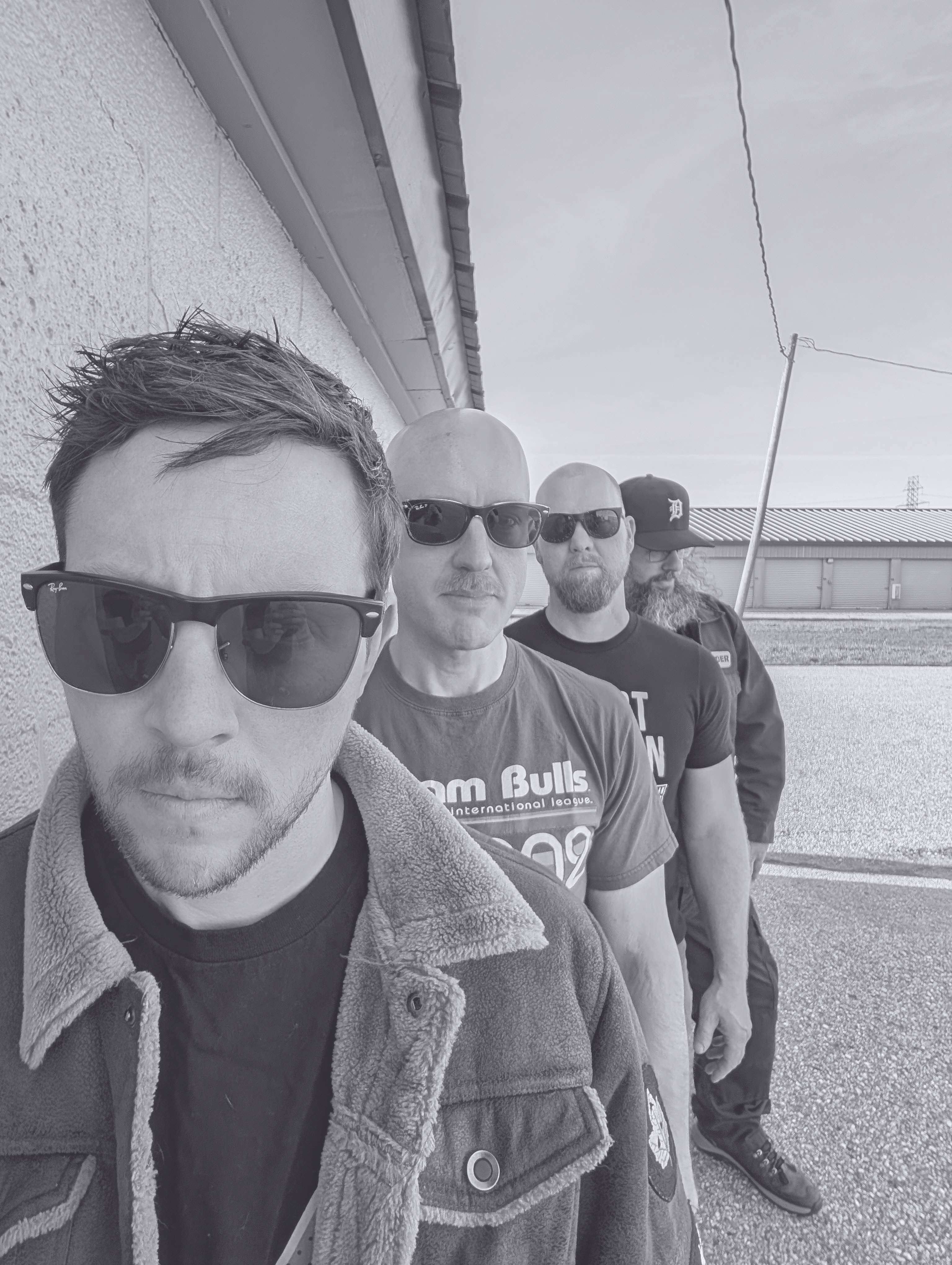 a black and white photo of a group of men wearing sunglasses