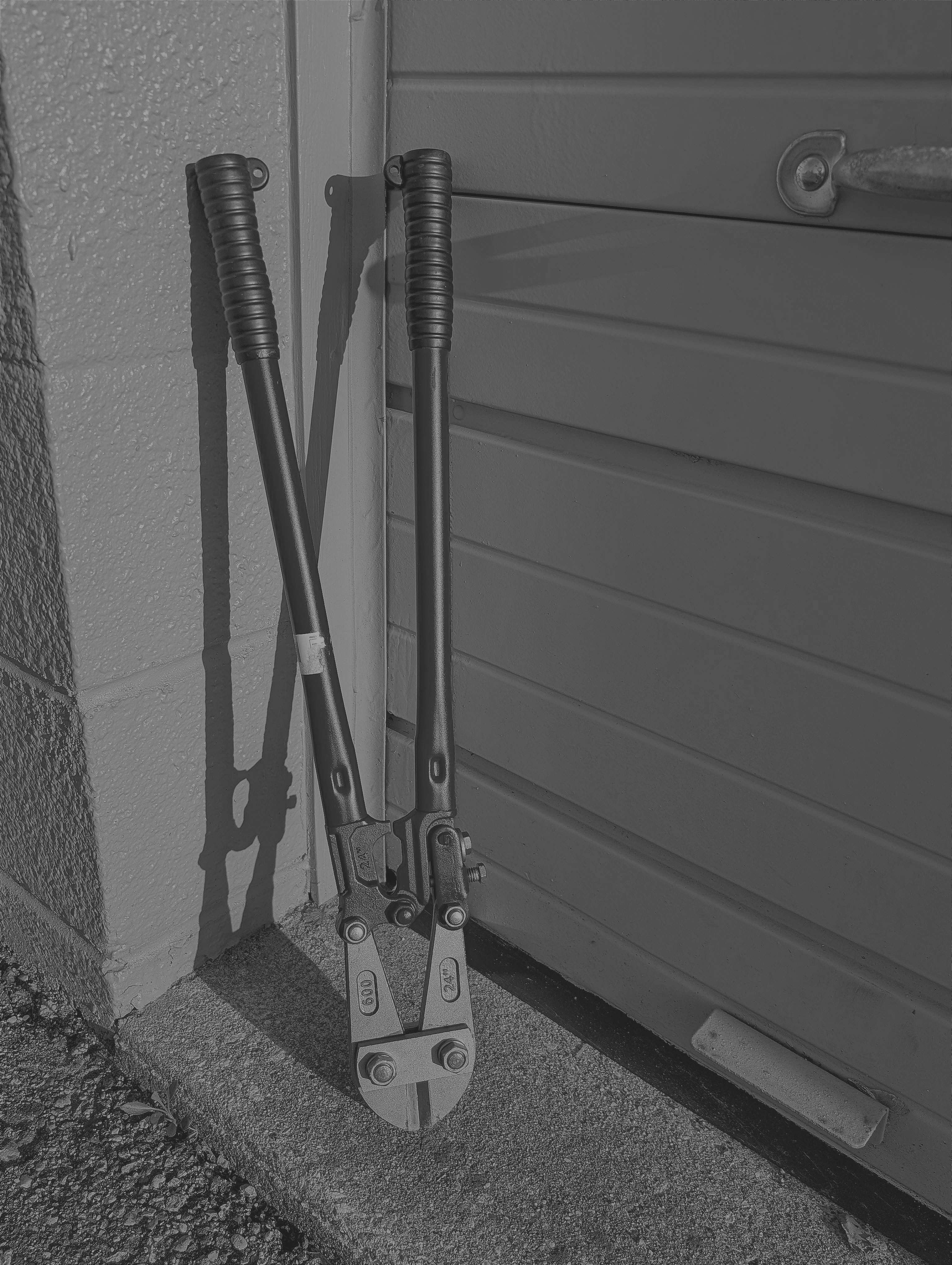 a pair of pliers leaning against the side of a garage door