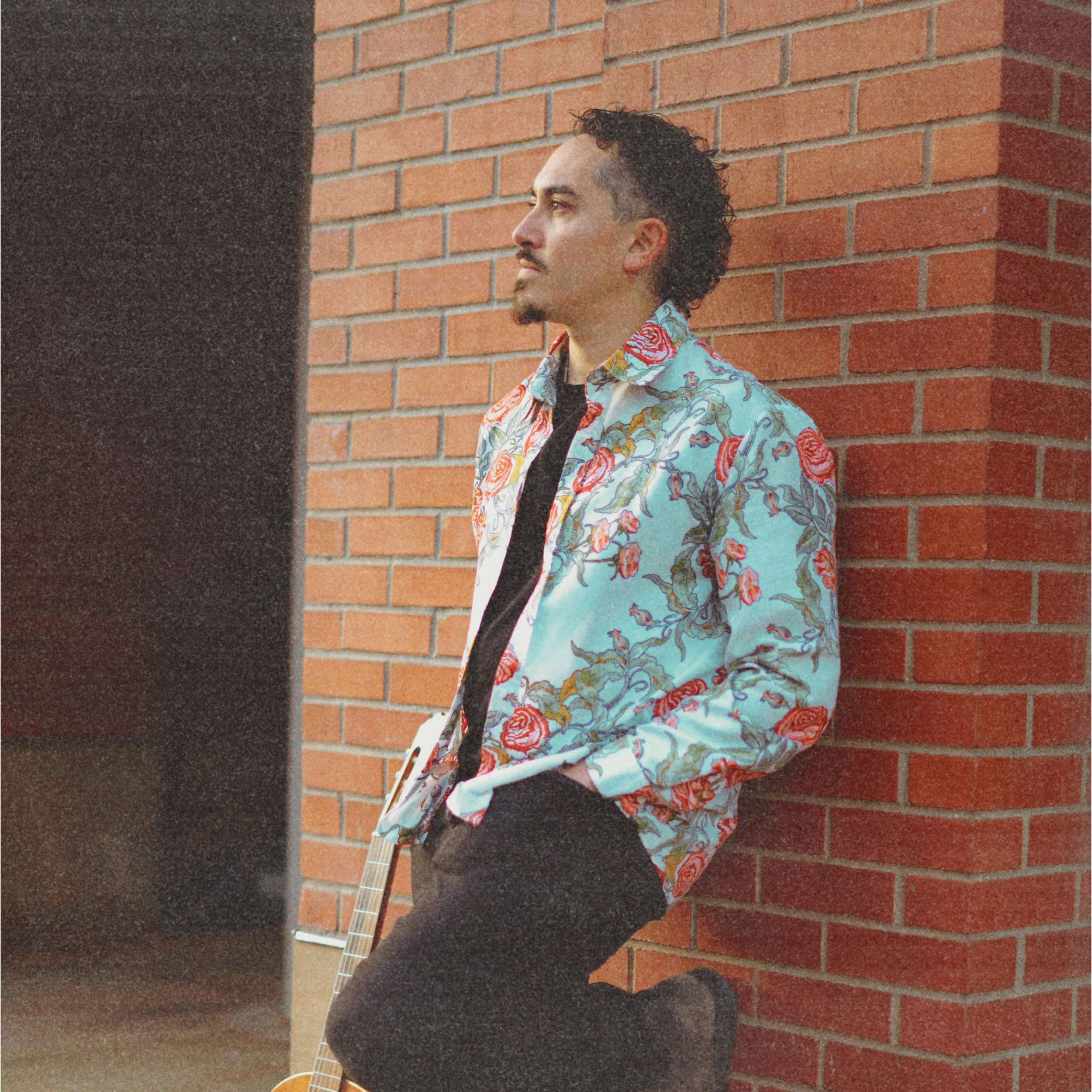 a man leaning against a brick wall