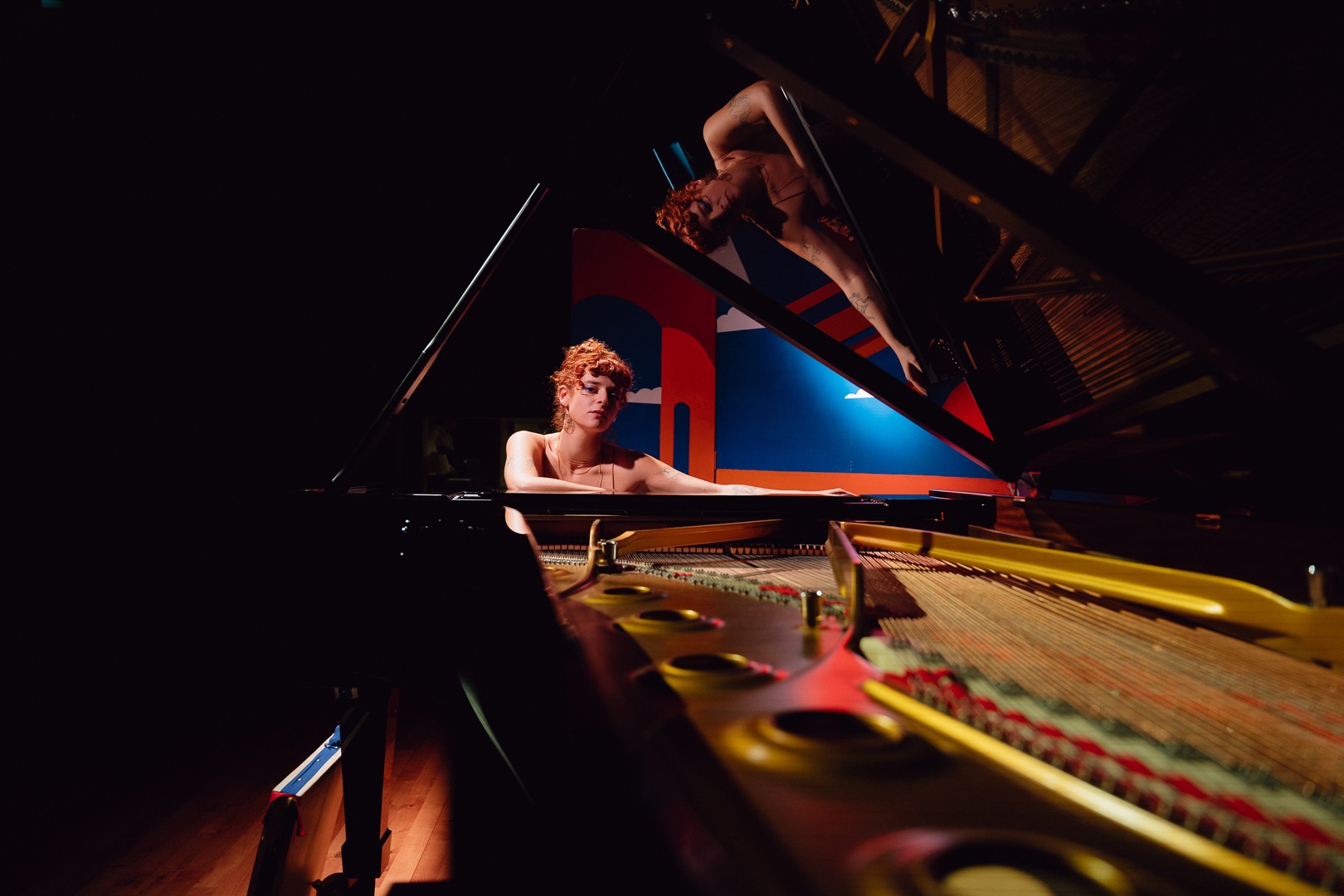 a woman playing a piano in a dark room