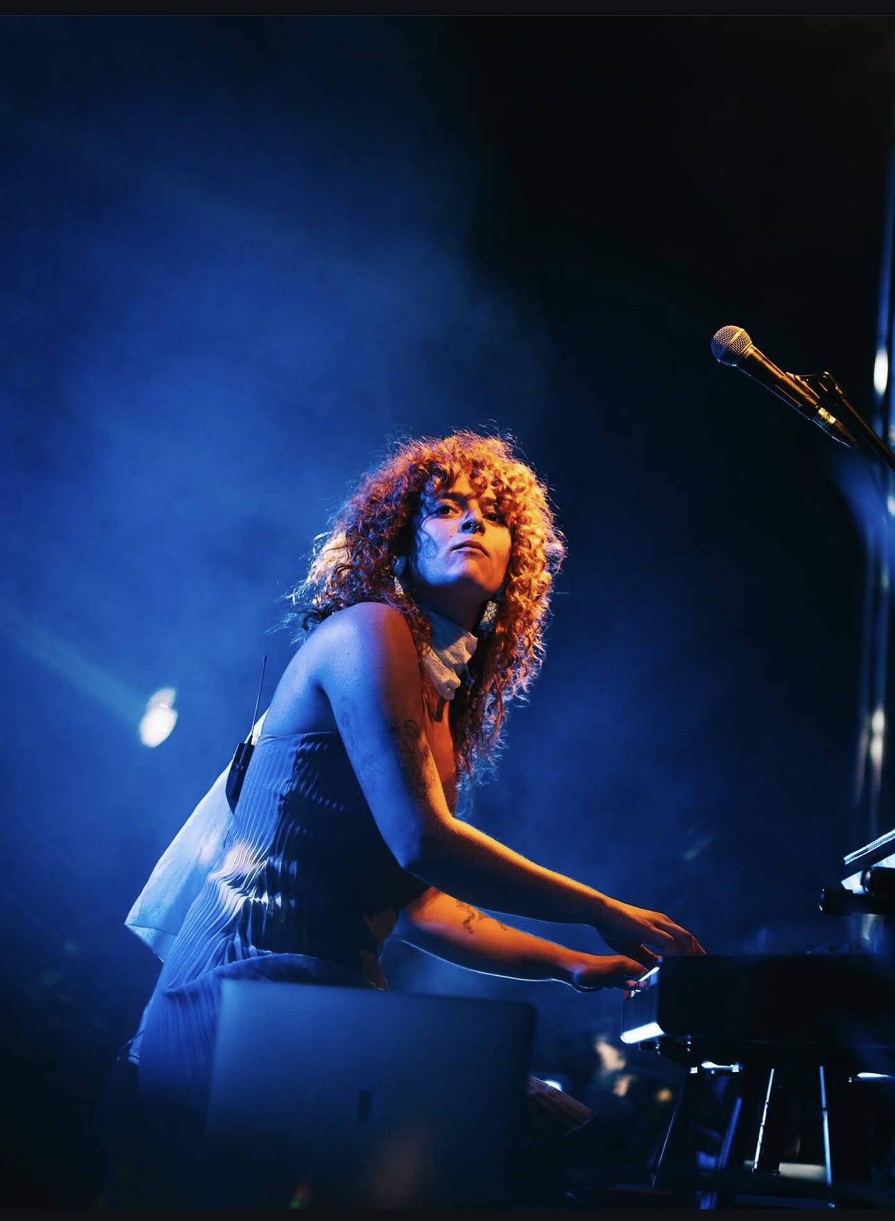 a woman with curly hair playing a keyboard