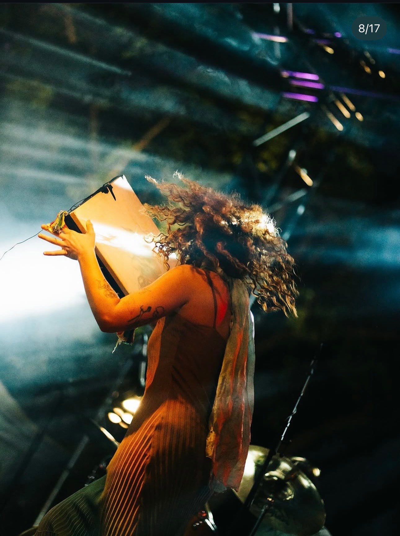 a woman in a dress on stage with a microphone