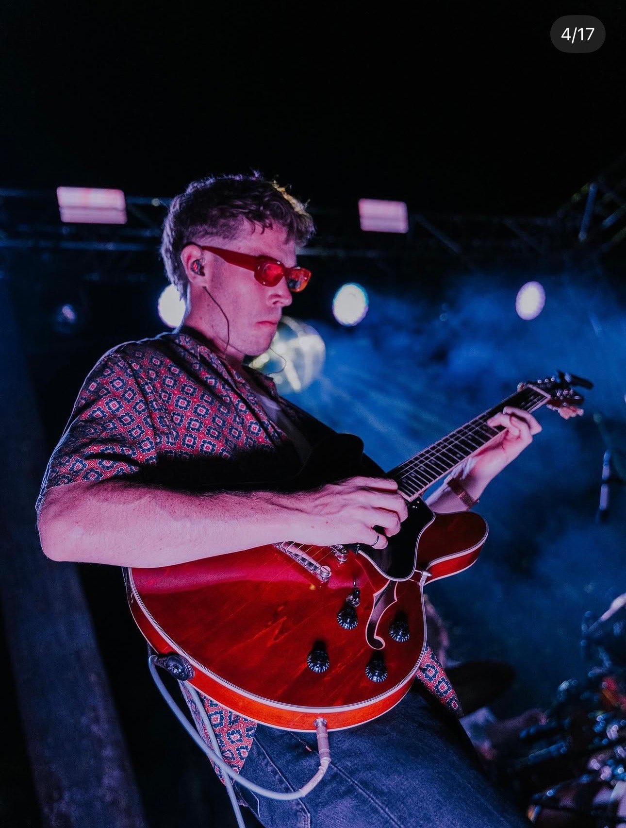 a man in glasses playing a guitar on stage