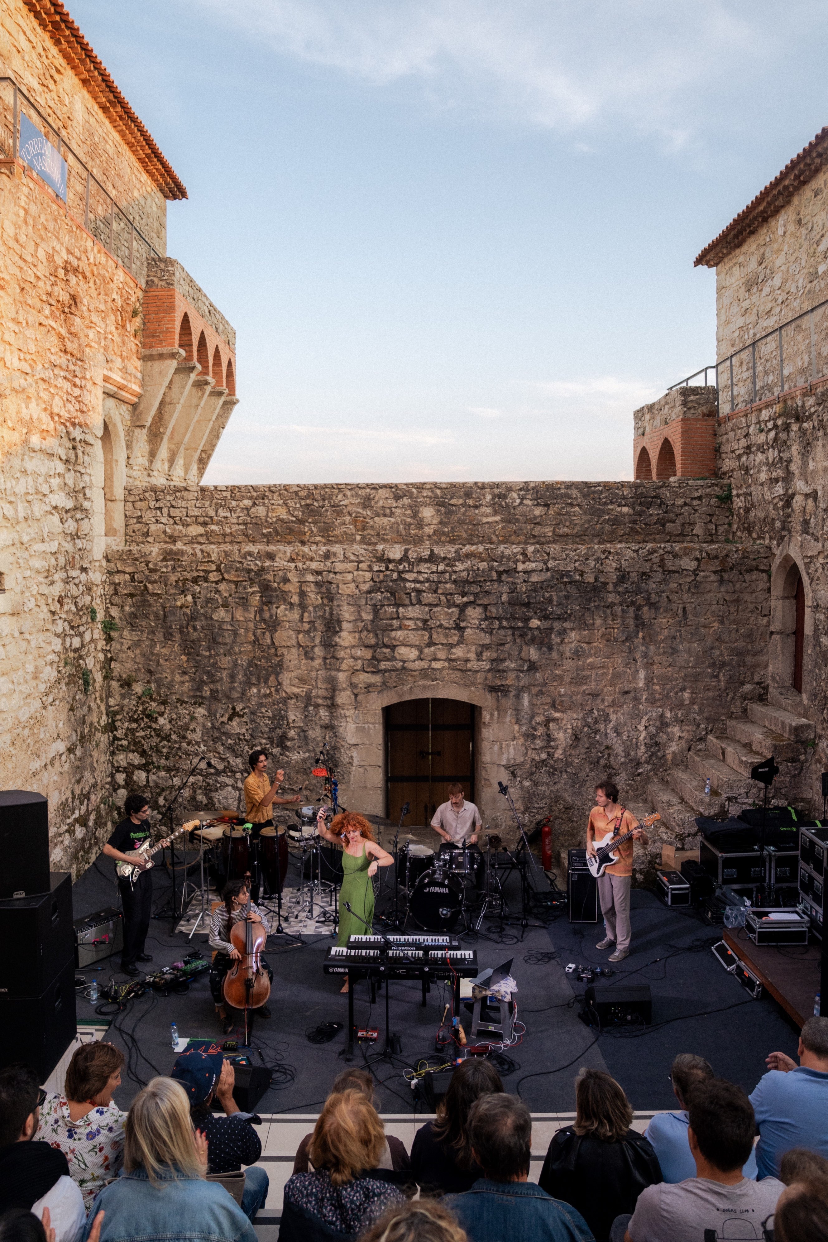 a group of people on a stage in front of a castle