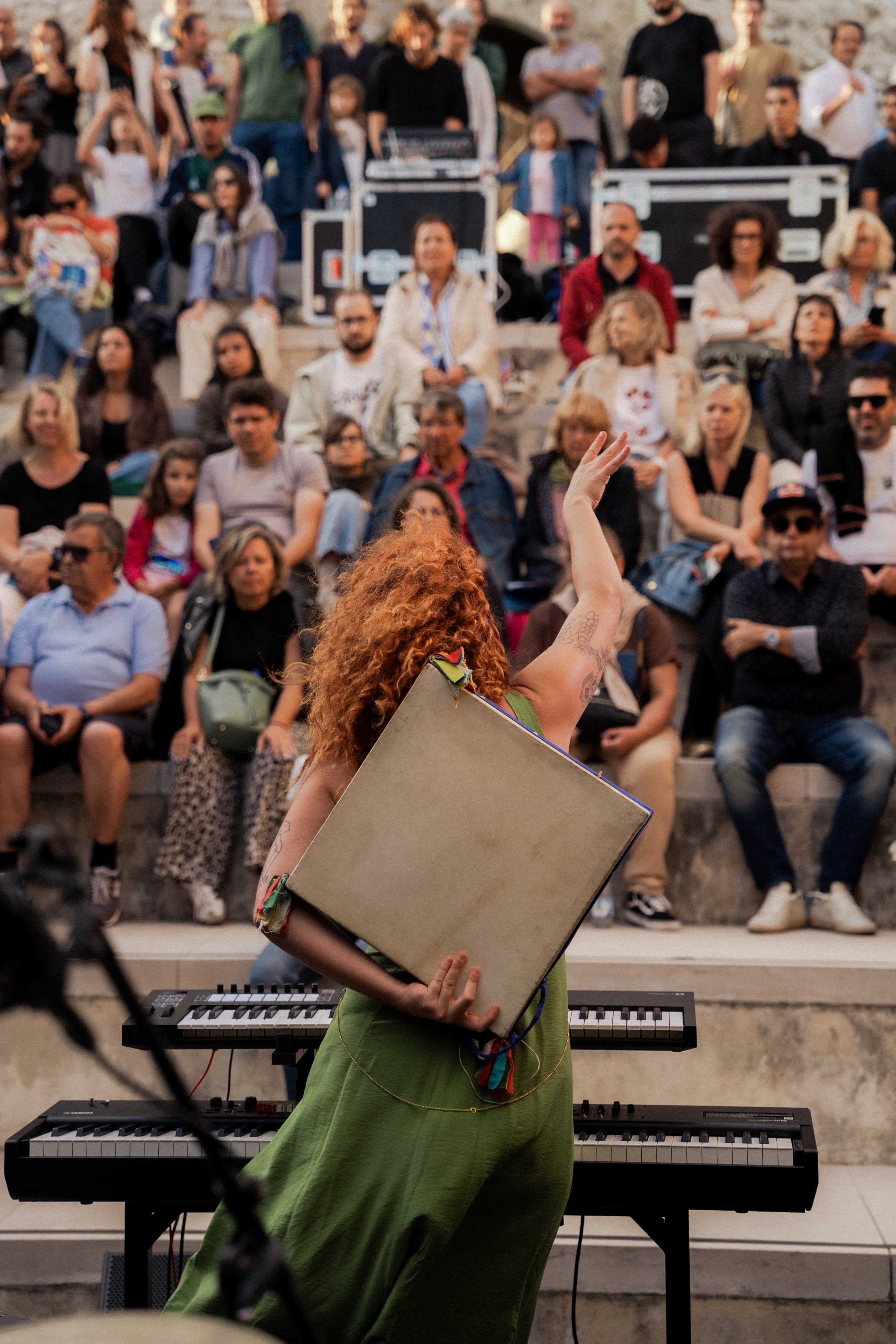 a woman playing a keyboard in front of a crowd of people