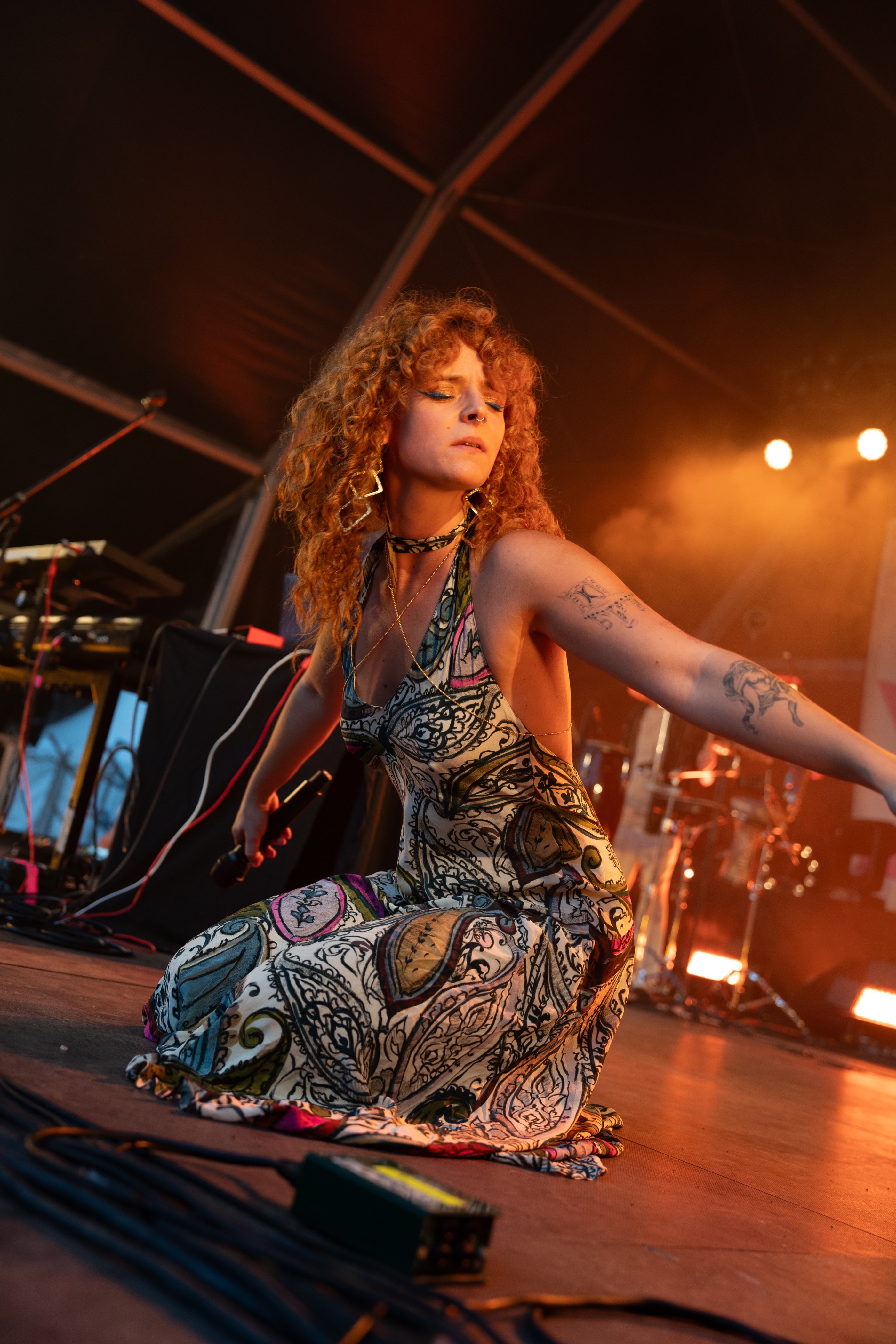a woman in a dress on stage at a music festival