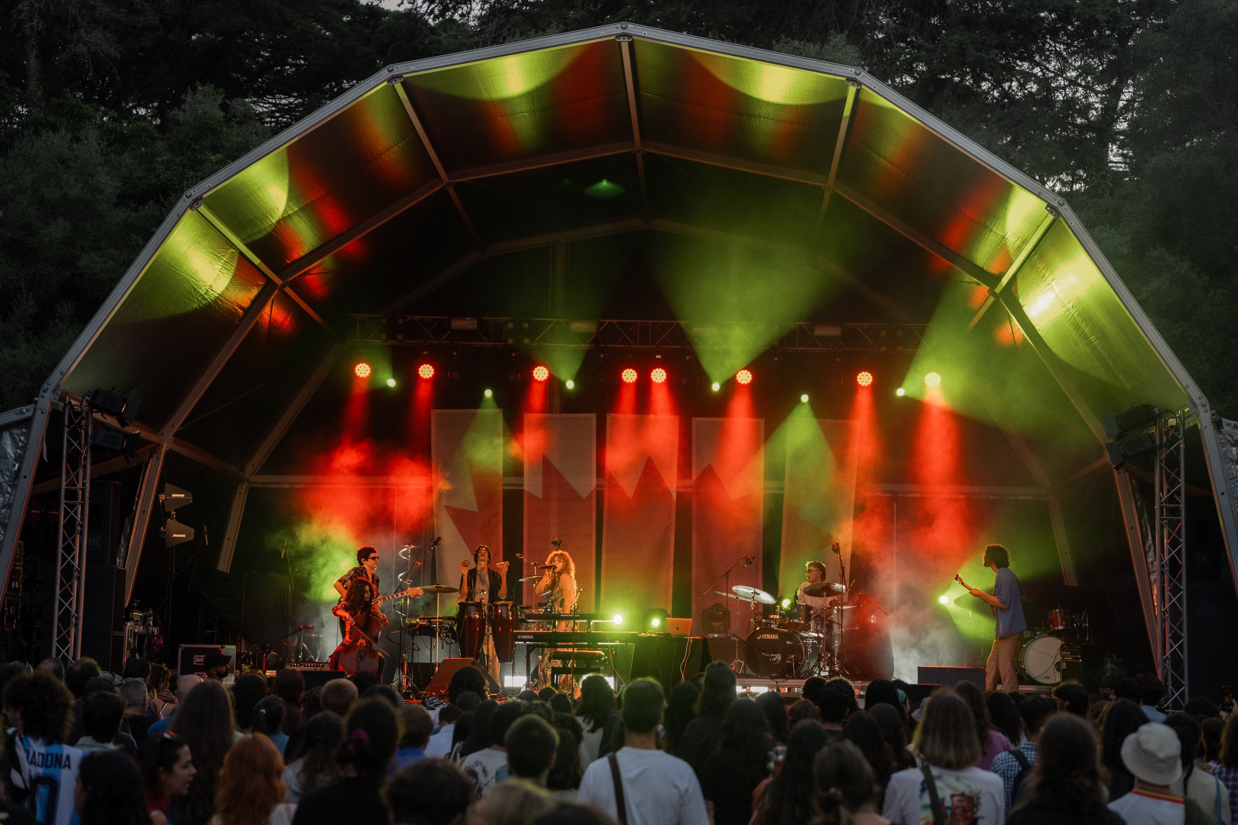 a group of people on stage at an outdoor concert