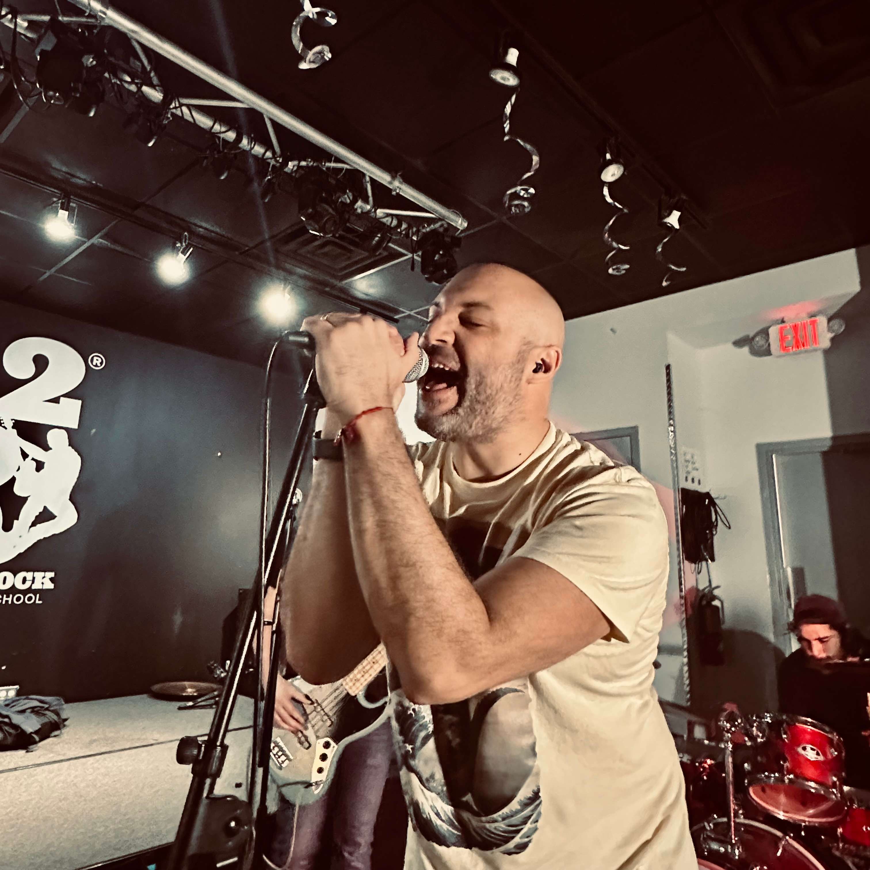 a bald man singing into a microphone