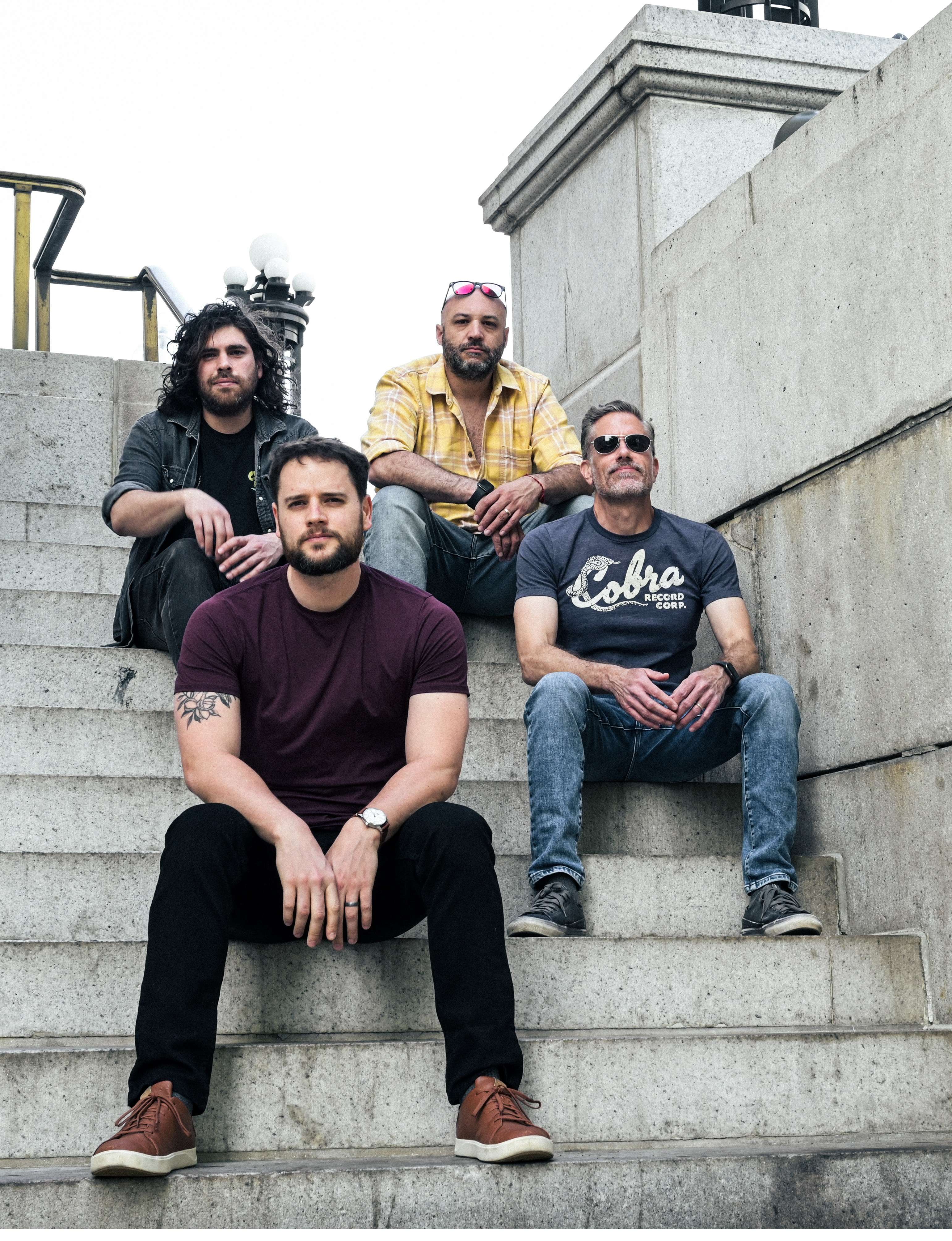 a group of men sitting on steps in front of a building