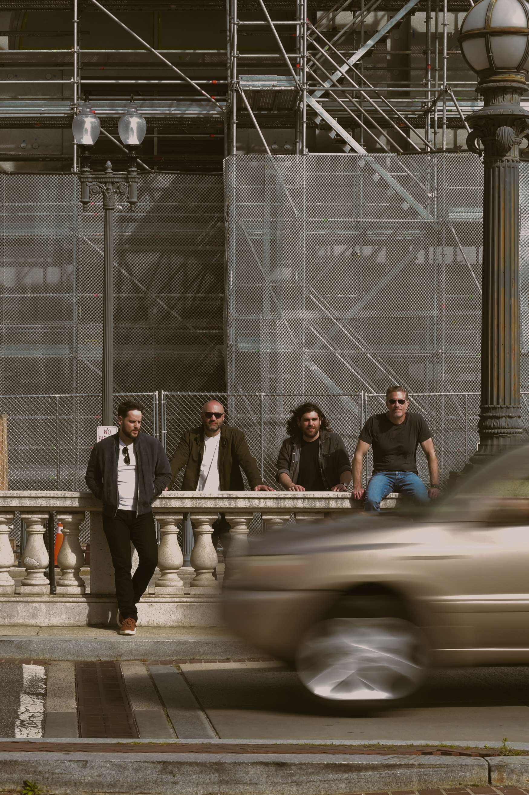 a group of people sitting on a railing in front of a building