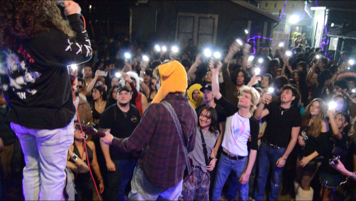 a man holding a cell phone in front of a crowd