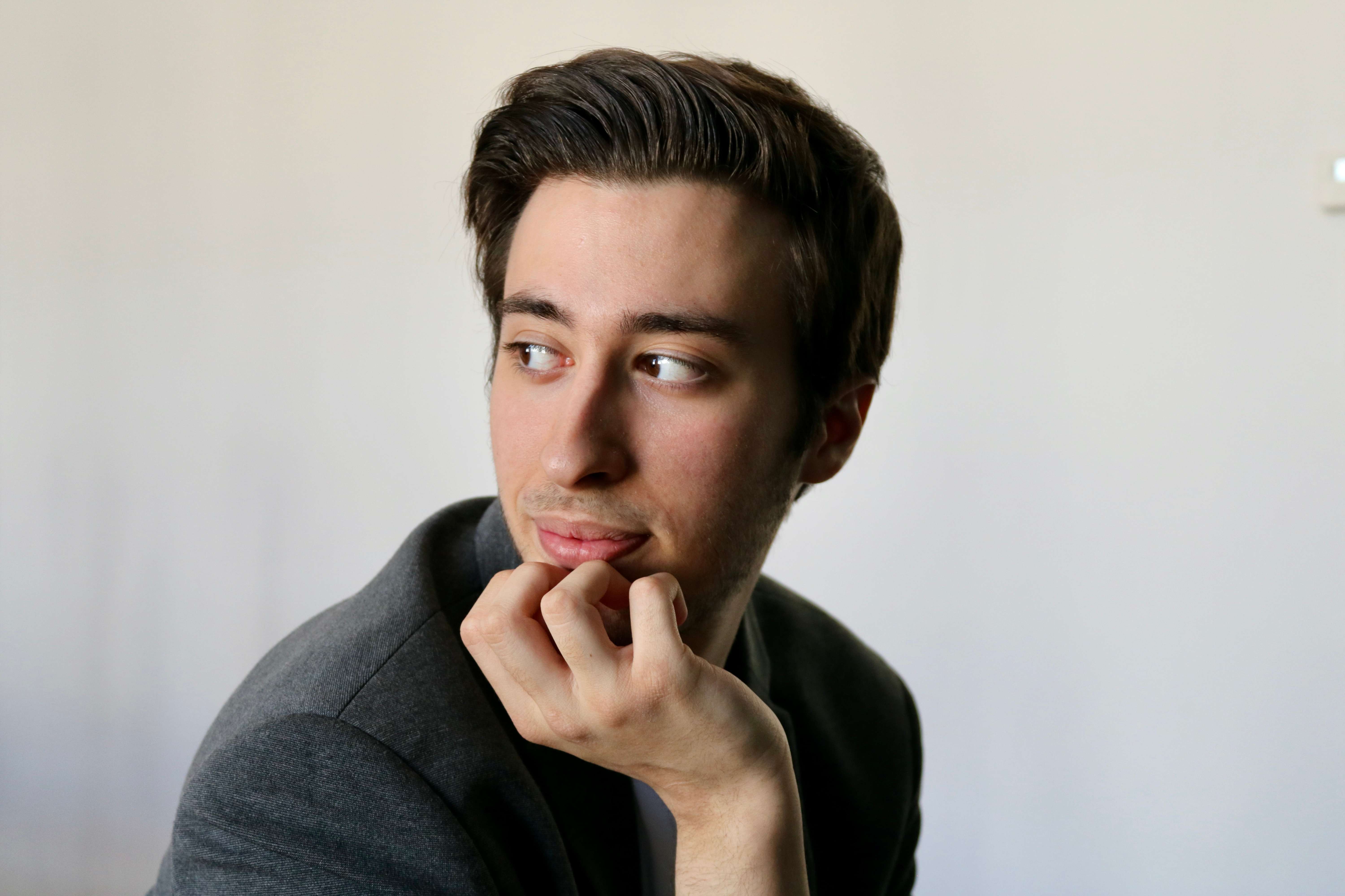 a young man with his hand on his chin