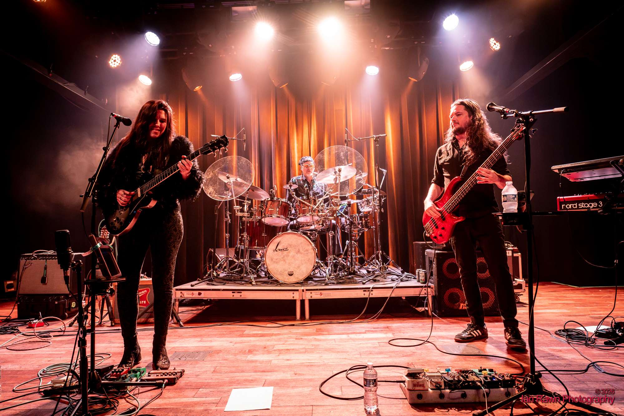 a group of people on stage with guitars and drums