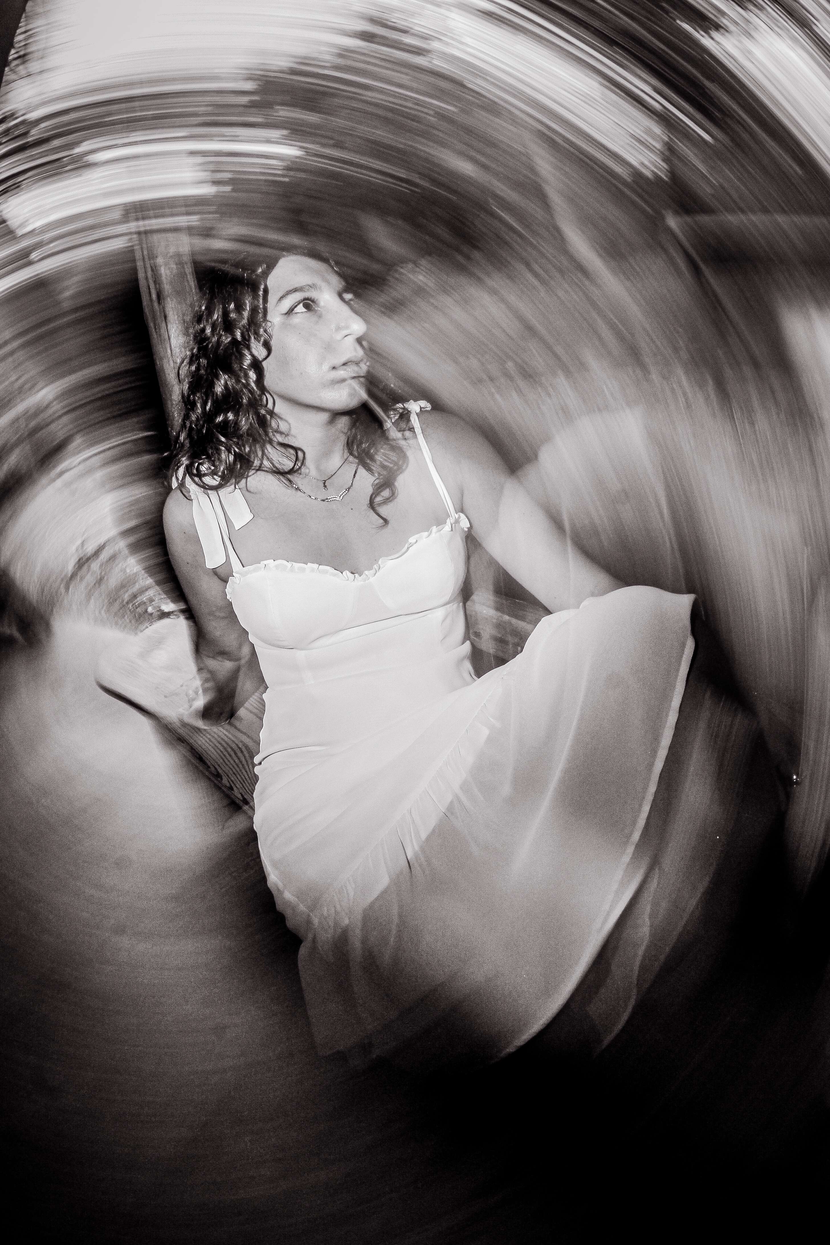 a woman in a white dress sitting in a circular motion
