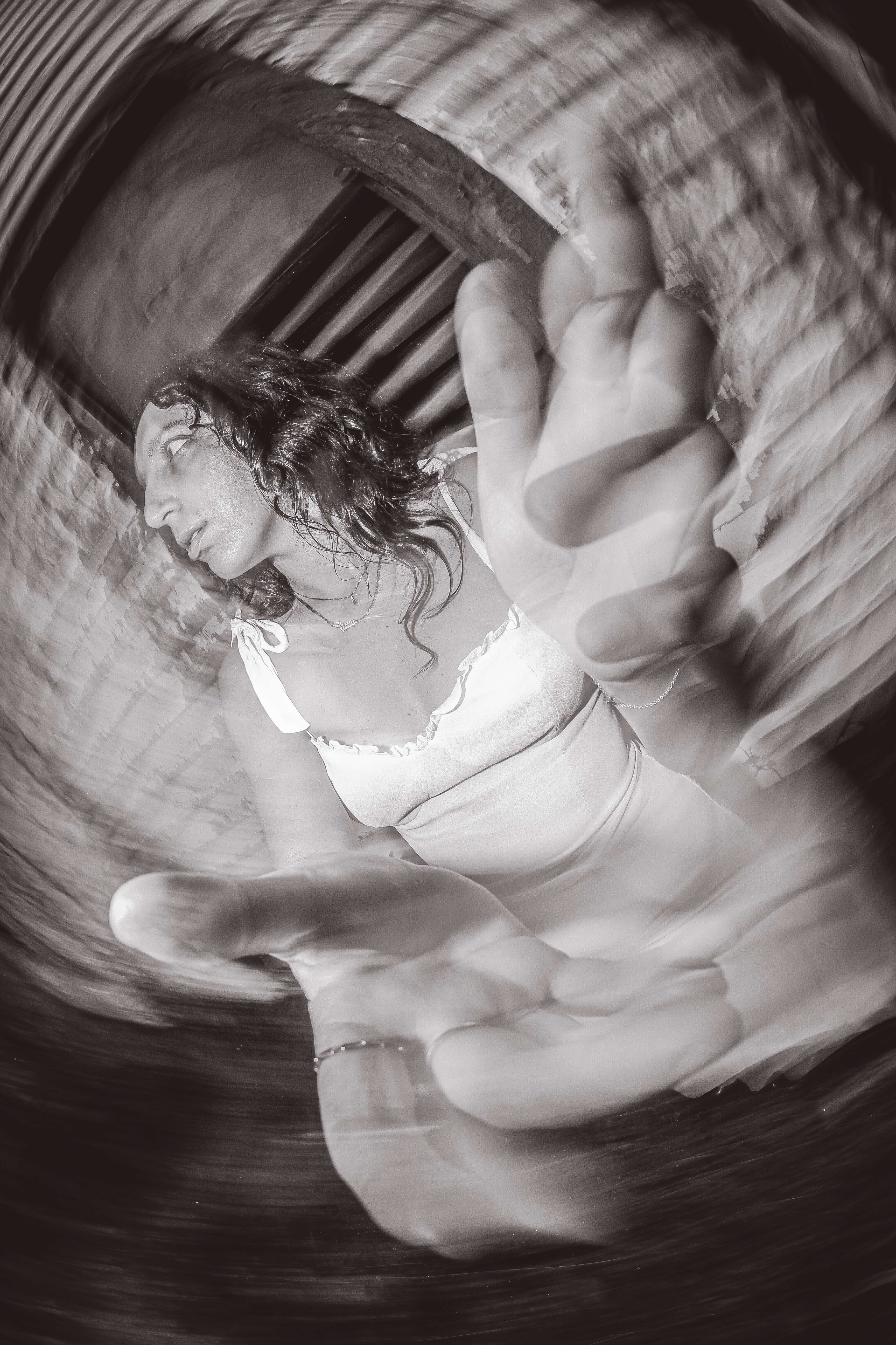 a black and white photo of a woman in a white dress