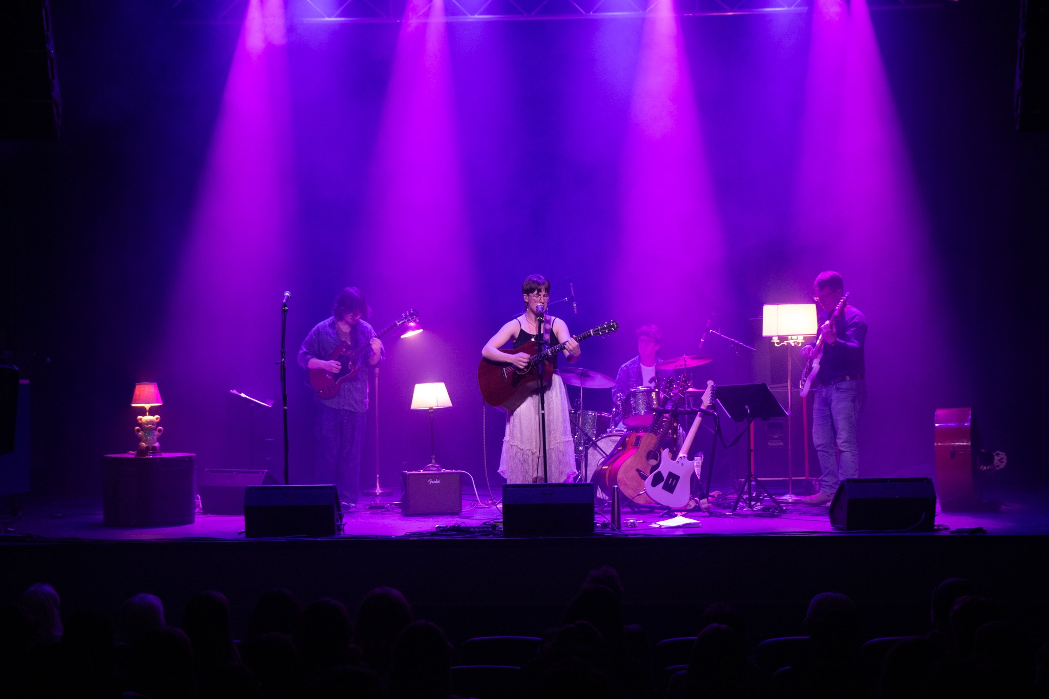 a group of people on stage with purple lights