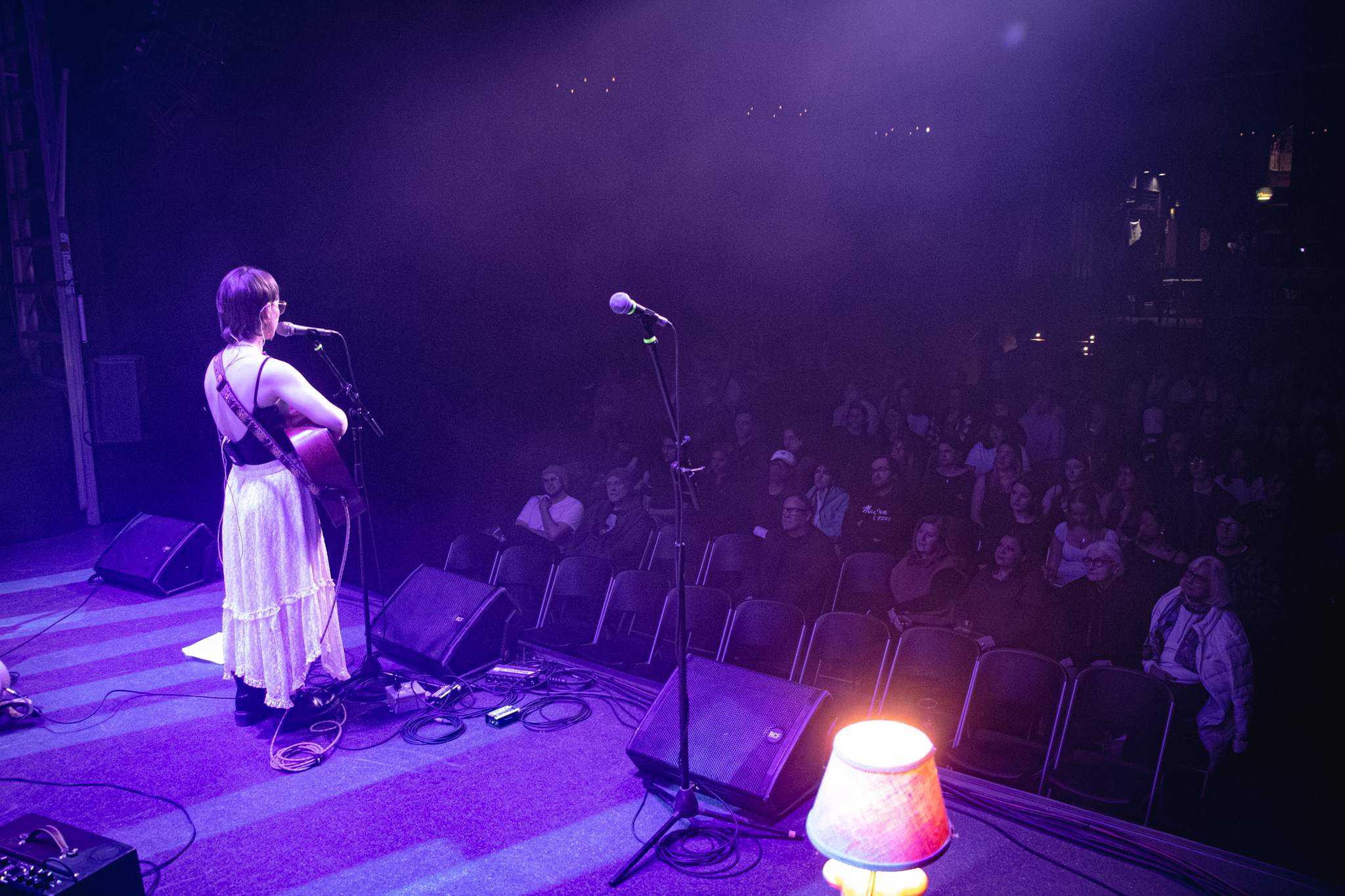 a woman singing on stage in front of an audience